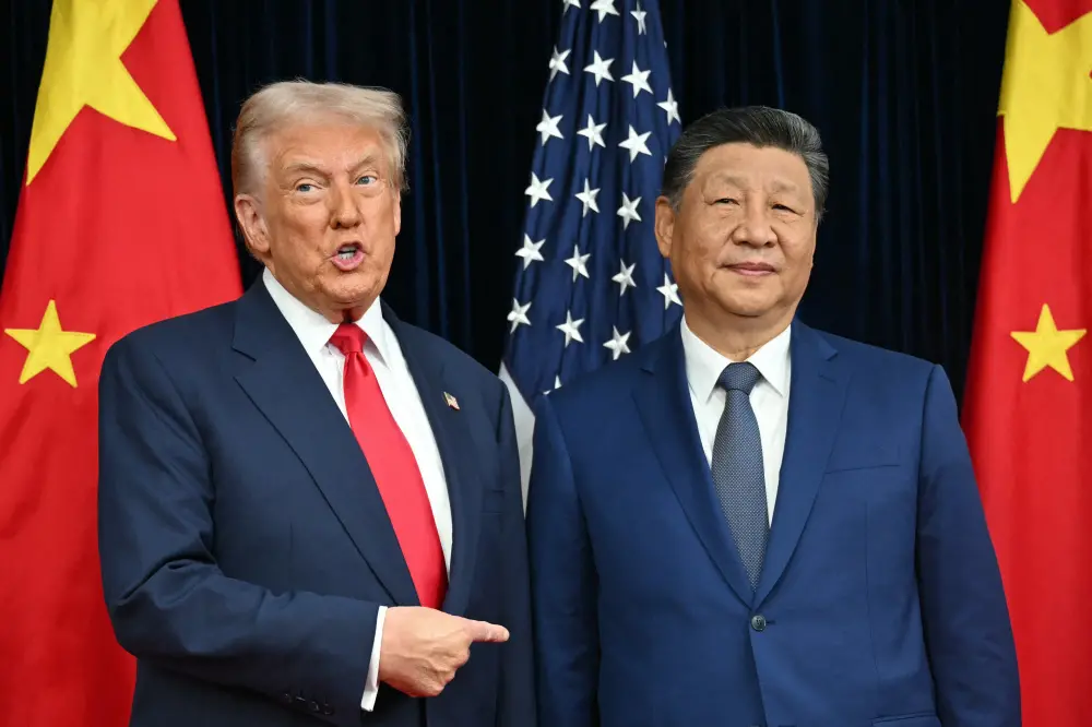 US President Donald Trump and China's President Xi Jinping greet each other as they arrive for talks at the Gimhae Air Base in Busan | AFP
