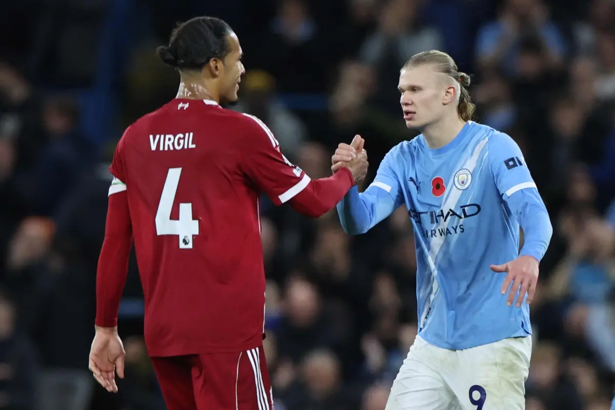 Liverpool's Dutch defender #04 Virgil van Dijk (L) shakes hands with Manchester City's Norwegian striker #09 Erling Haaland (R) at the end of the English Premier League football match between Manchester City and Liverpool at the Etihad Stadium in Manchester, north west England. | Photo: AFP
