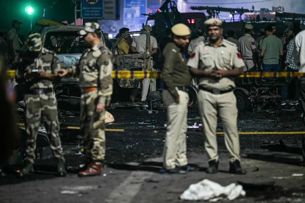 Security personnel stand beside charred vehicles at the blast site after an explosion near the Red Fort in the old quarters of Delhi (Photo: AFP)