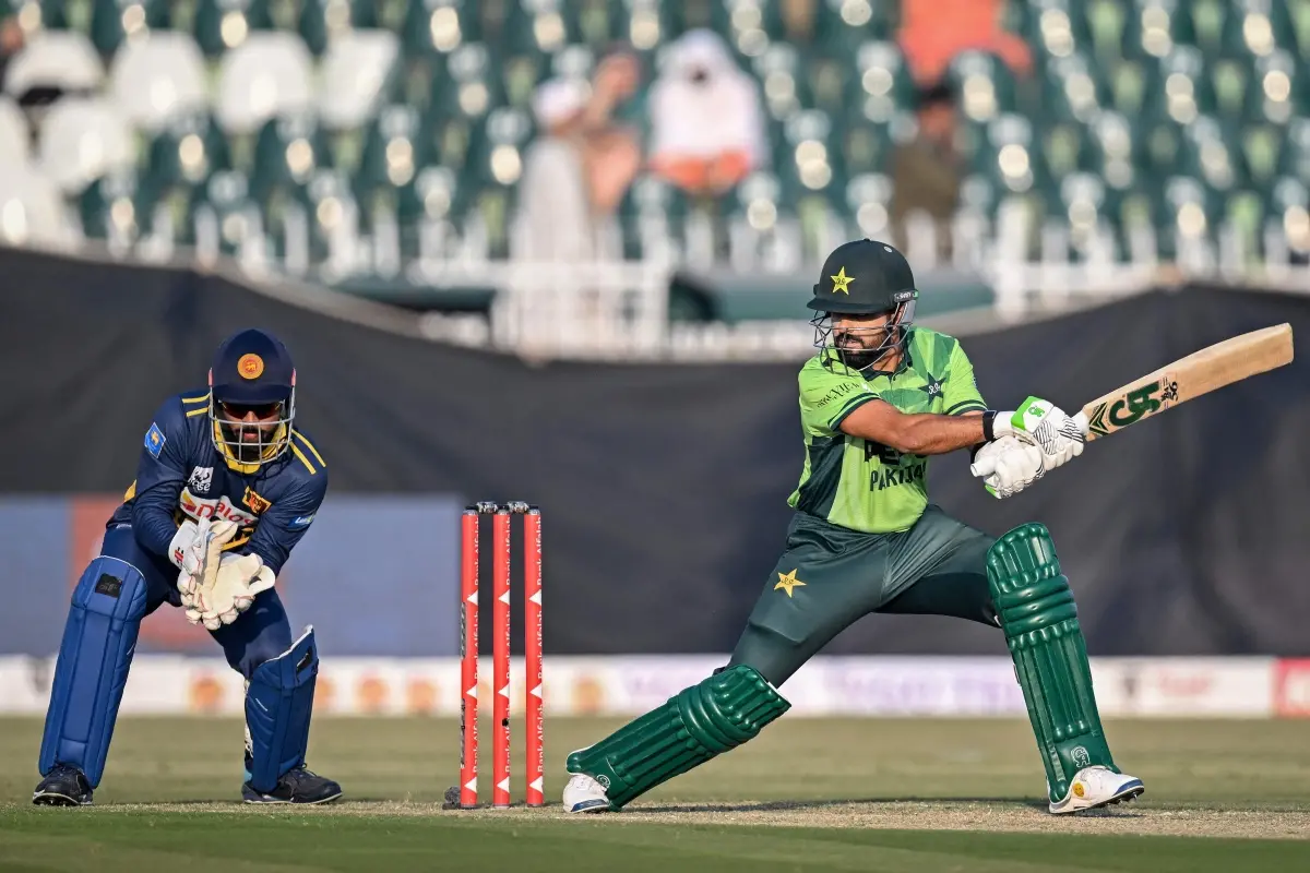 Pakistan's Babar Azam (R) plays a shot as Sri Lanka's wicketkeeper Kusal Mendis looks on during the first one-day international (ODI) cricket match between Pakistan and Sri Lanka at the Rawalpindi Cricket Stadium. | Photo: AFP