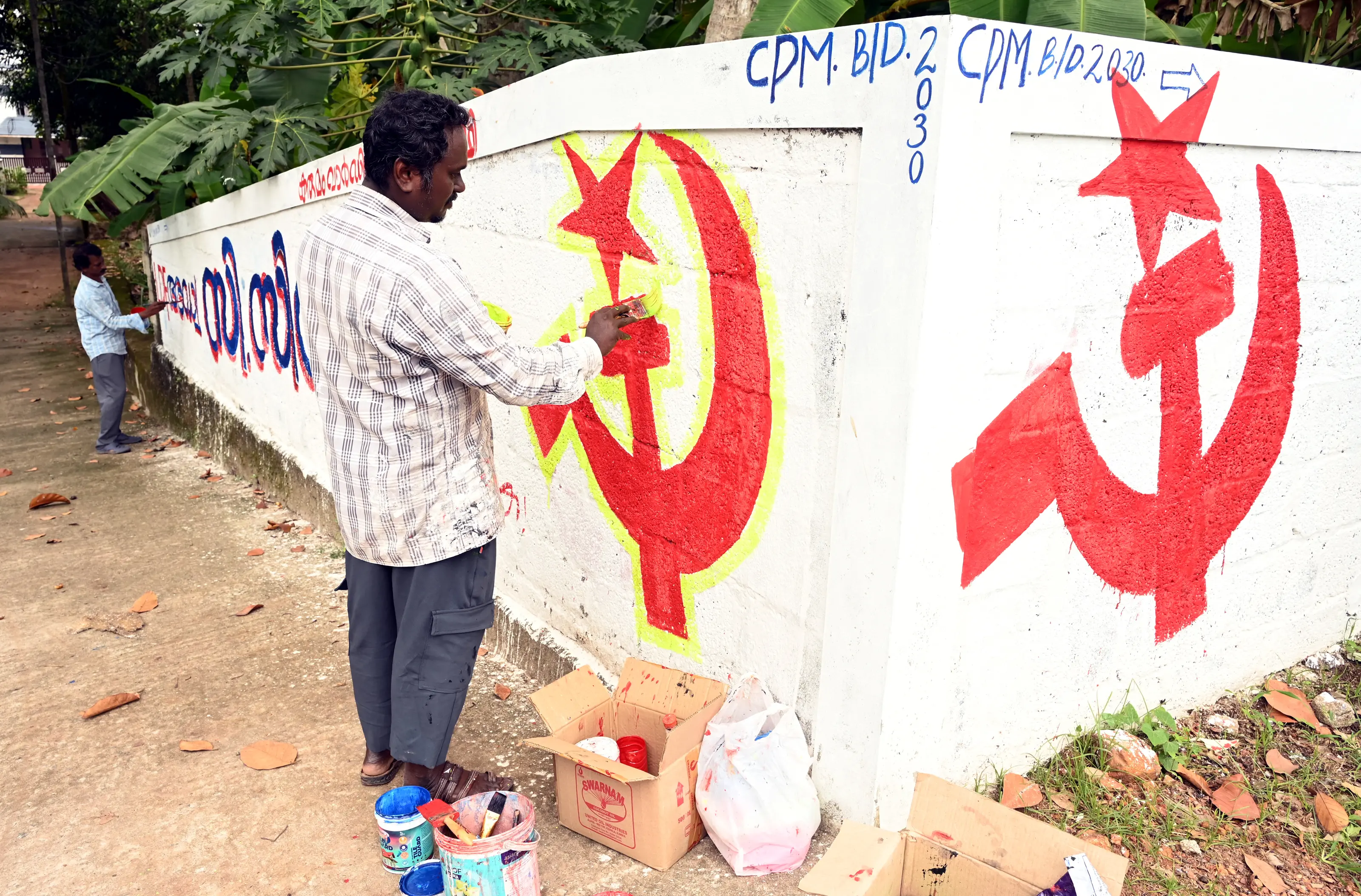 Artists paint the LDF symbol on a wall as part of preparations for the upcoming Kerala local body elections | PTI