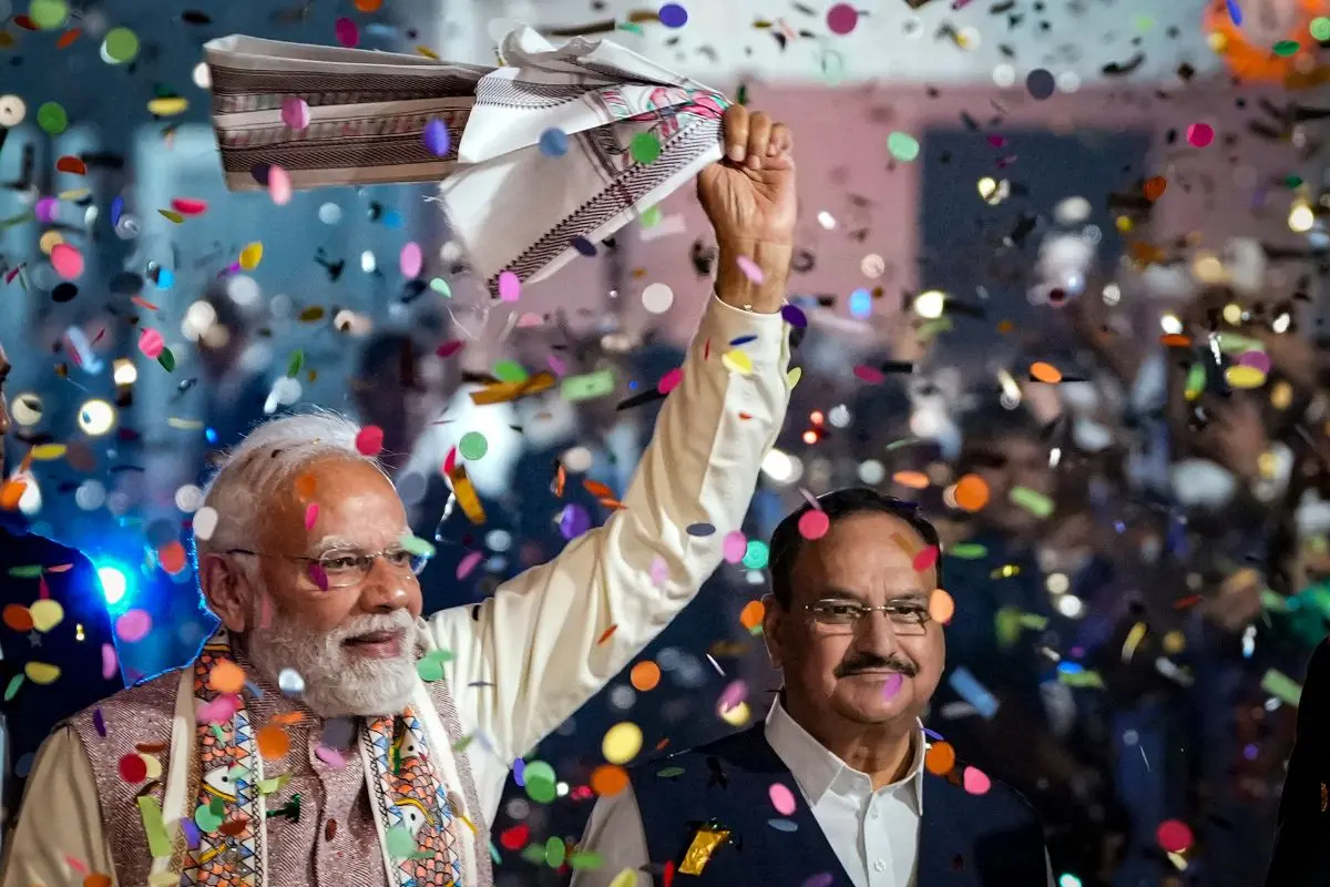 Prime Minister Narendra Modi waves a 'gamcha' as he arrives during the celebration of NDA's victory in the Bihar Assembly elections, at BJP headquarters, in New Delhi, on Friday, Nov 14, 2025. Union Health Minister and BJP national president JP Nadda is also seen | Photo: PTI
