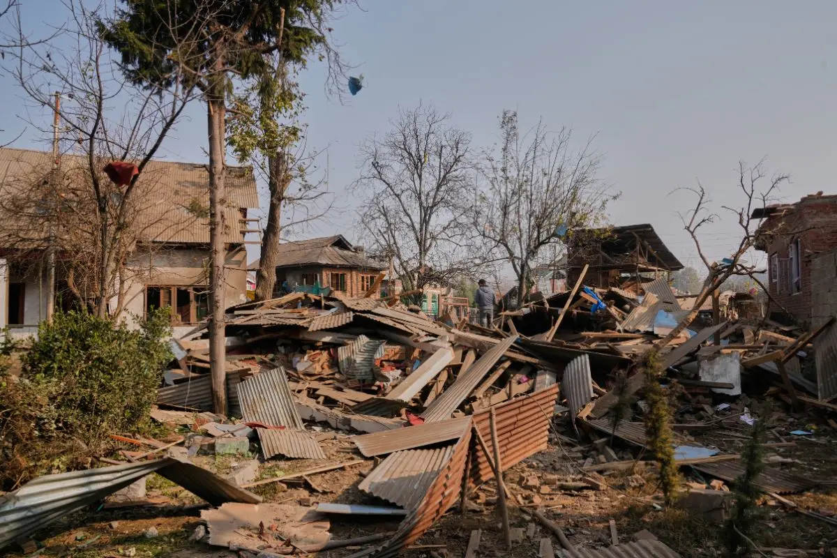 A Kashmiri man stands on the blown-up home of one of the key suspect behind this week's Delhi car blast, in Pulwama, south of Srinagar, Indian controlled Kashmir, Friday, Nov. 14, 2025 (Photo: AP)