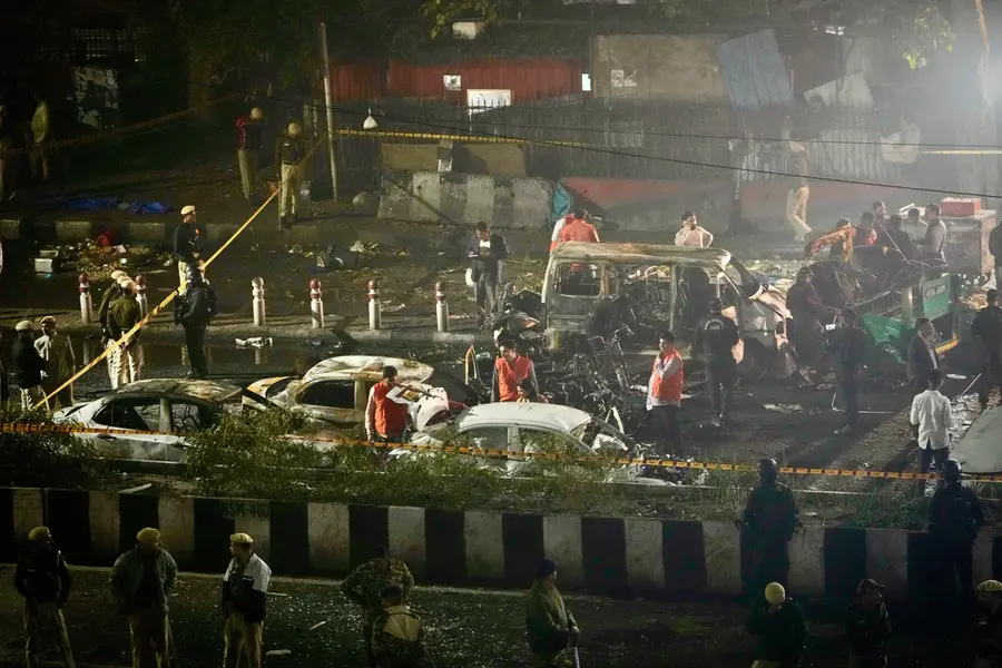 Security officials inspect the scene of a car explosion near the historic Red Fort in New Delhi