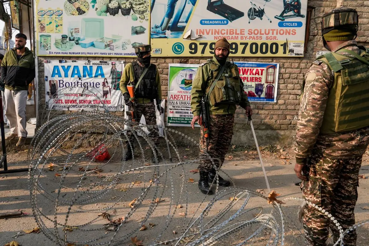 Security personnel stand guard on a blocked road leading to the Nowgam police station. (PTI Photo/S Irfan)