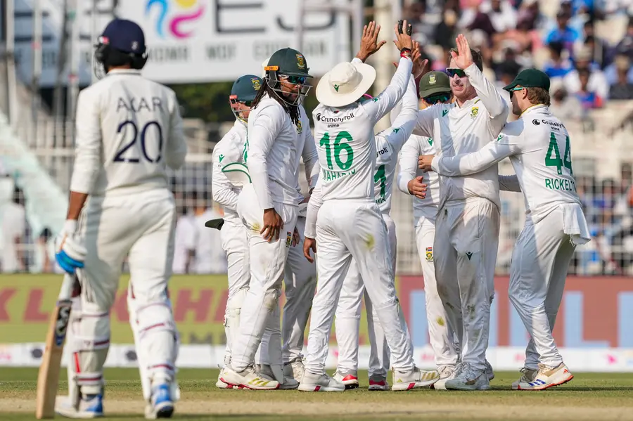 South Africa's Simon Harmer with teammates celebrates after the wicket of India's Kuldeep Yadav during the third day of the first Test cricket match of a series between India and South Africa