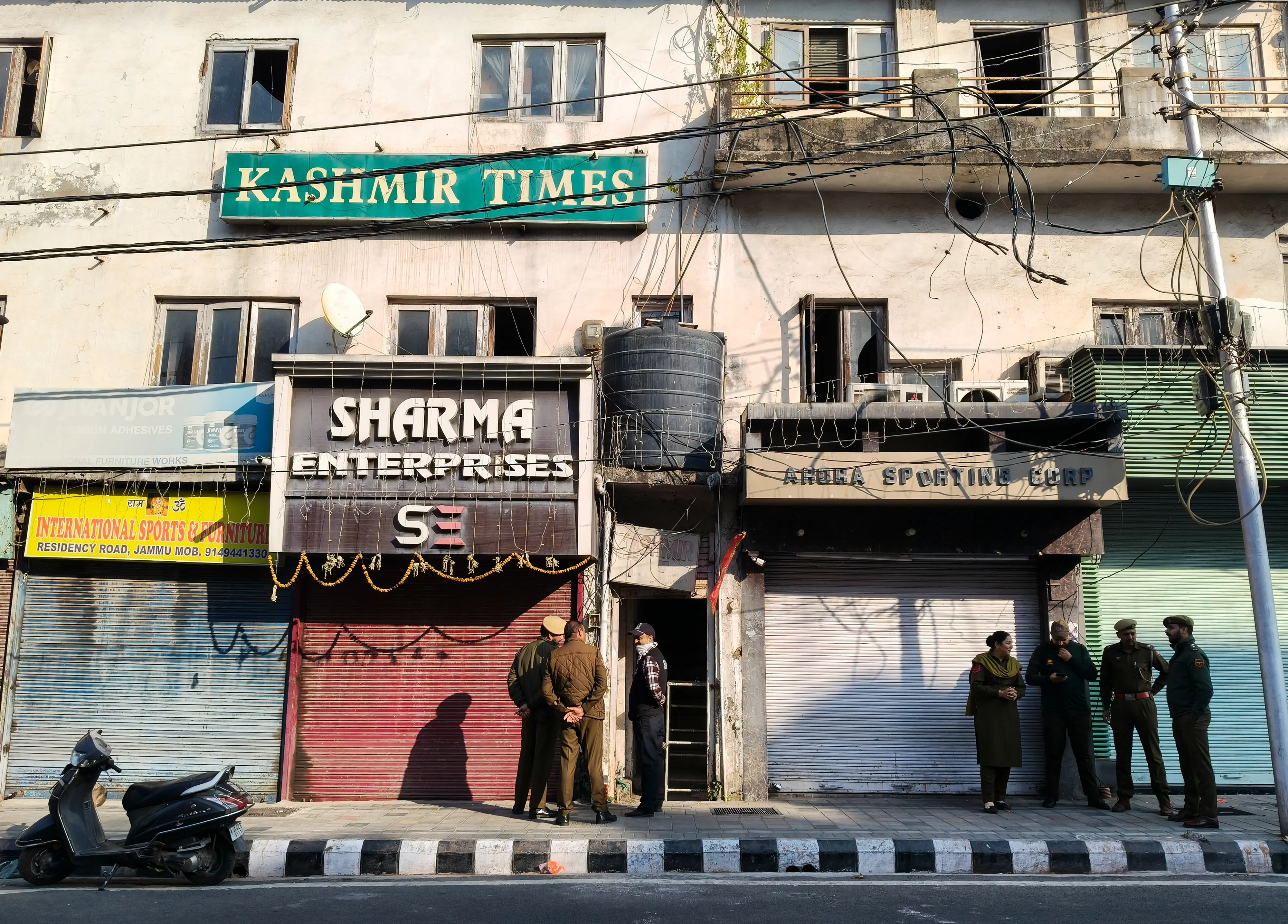 Officials outside the Kashmir Times office during a raid by State Investigation Agency (SIA) as part of an ongoing probe into a terror module case, in Jammu, Thursday, Nov. 20, 2025. | Photo: PTI