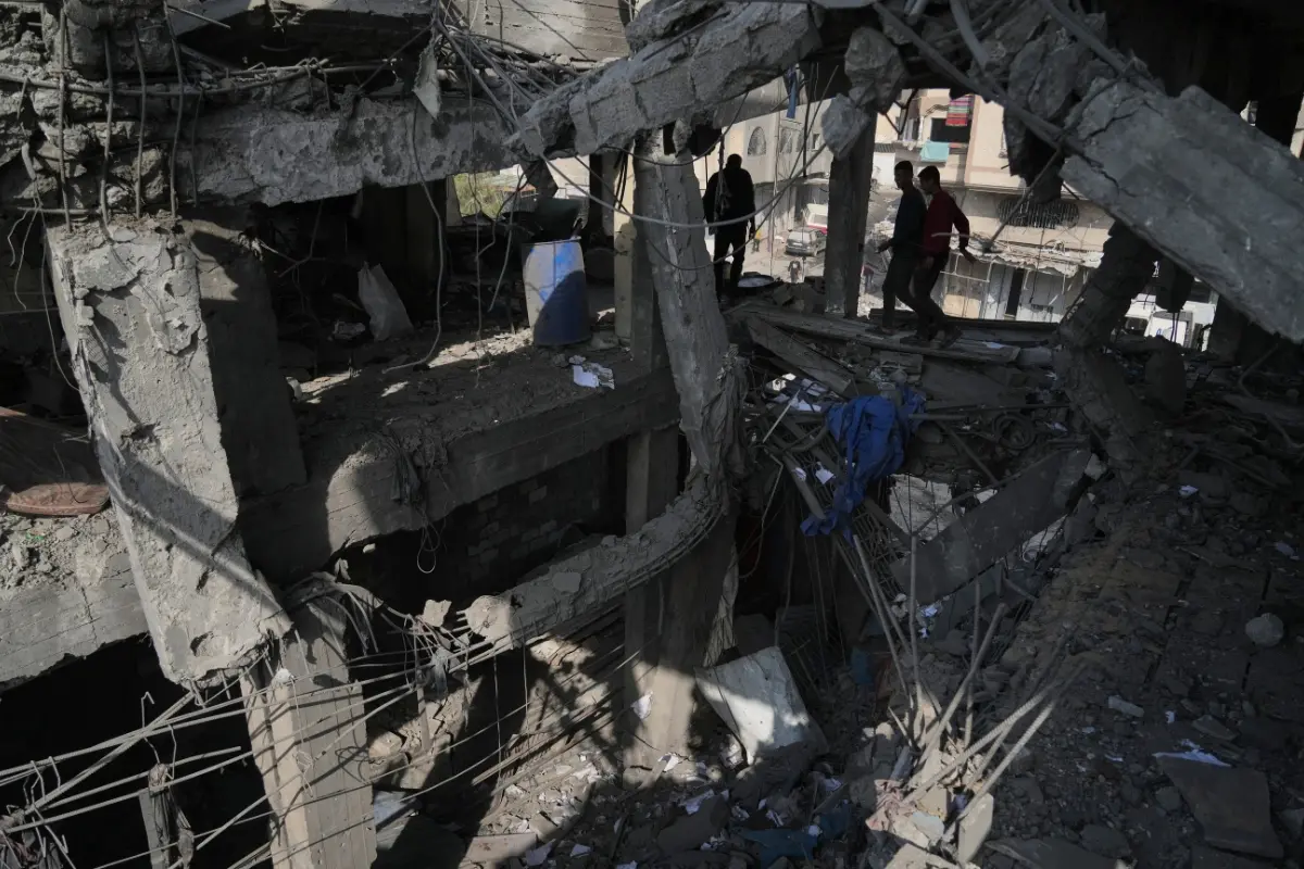 Palestinians inspect the ruins a day after an Israeli strike on a building in Gaza City | Photo: AP