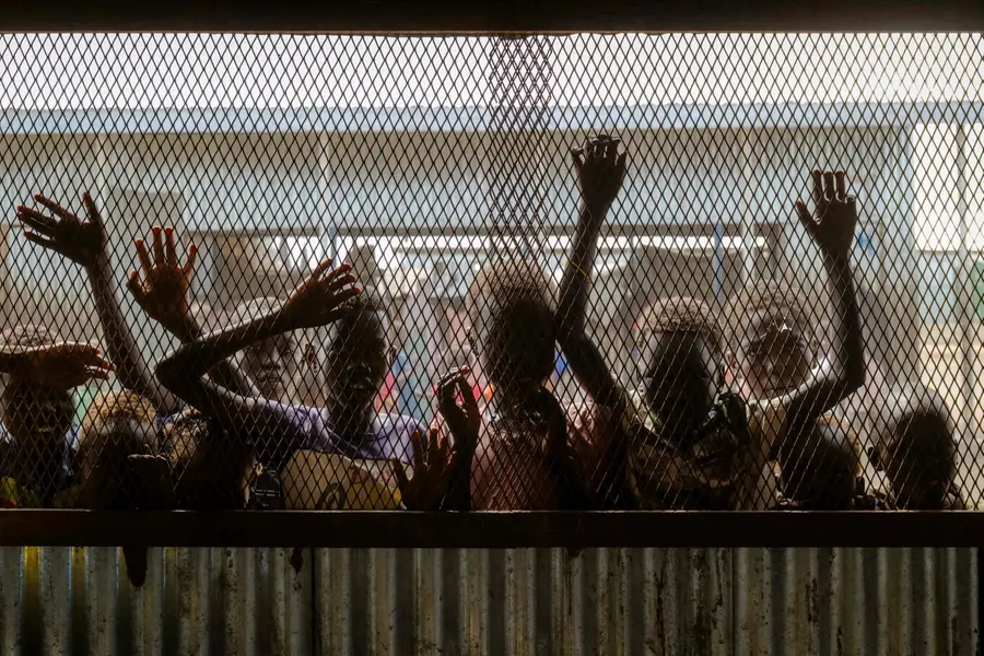 Children gather at the fenced window of a safe-space classroom managed by War Child Holland at the Renk Transit Center in Renk, South Sudan