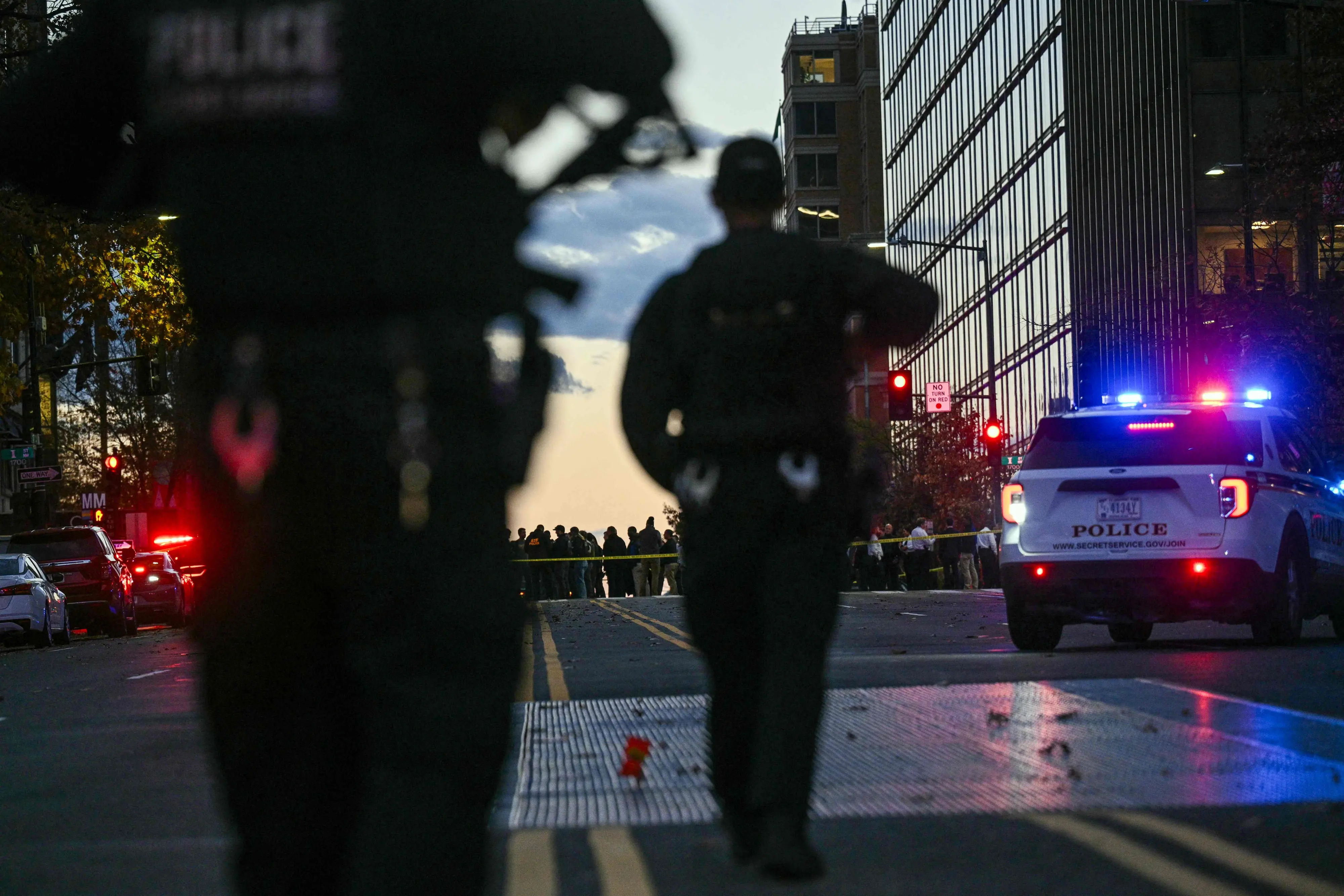 Police officers secure the area as law-enforcement officials visit the crime scene of a shooting in downtown Washington, DC | AFP