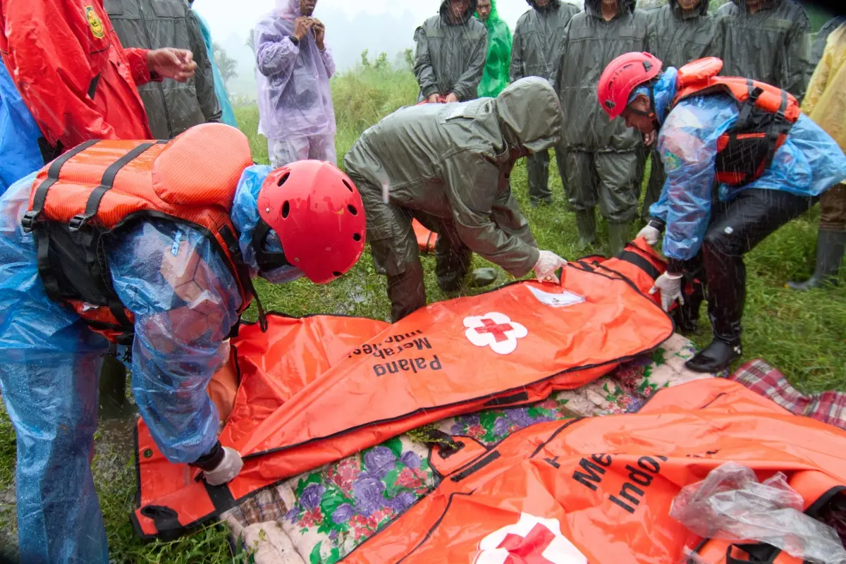 Rescuers put the bodies of flood victims in body bags, in Malalak, West Sumatra, Indonesia | Photo: AP