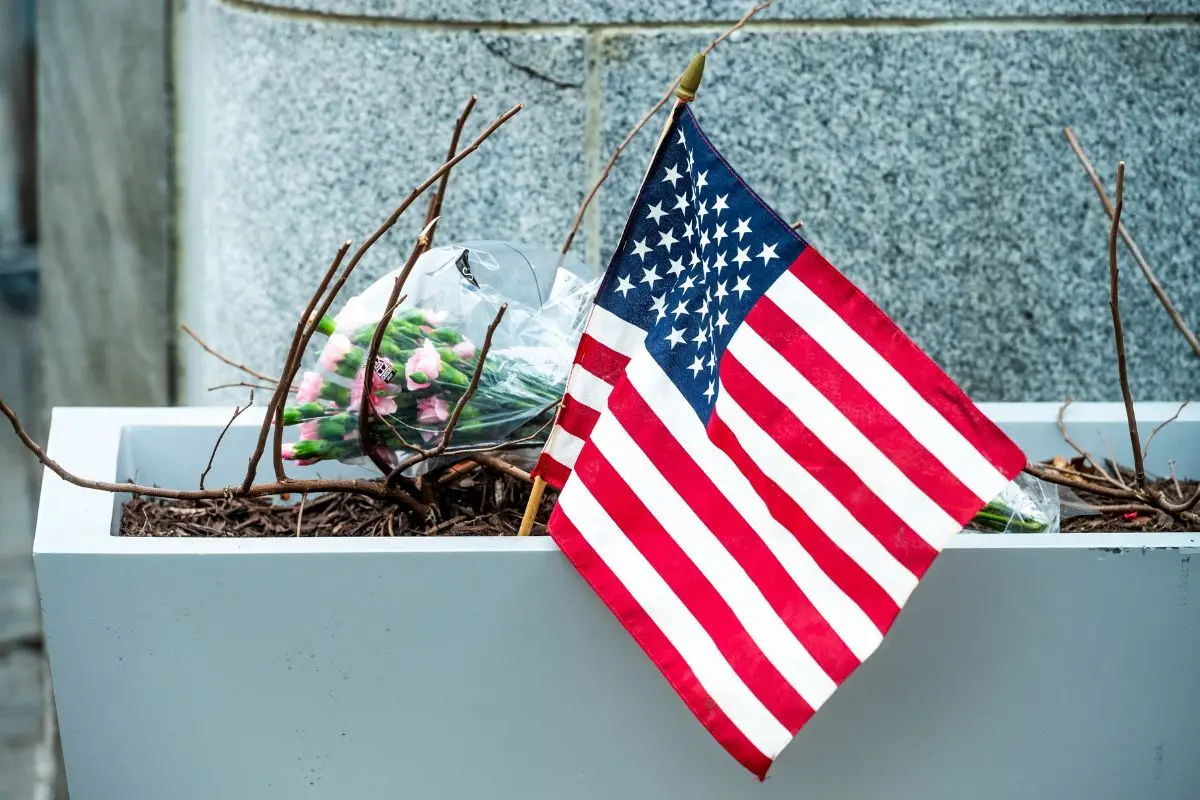 Flowers and an American flag, placed at the scene a day after two National Guard soldiers were shot near the White House in Washington. | Photo: AP