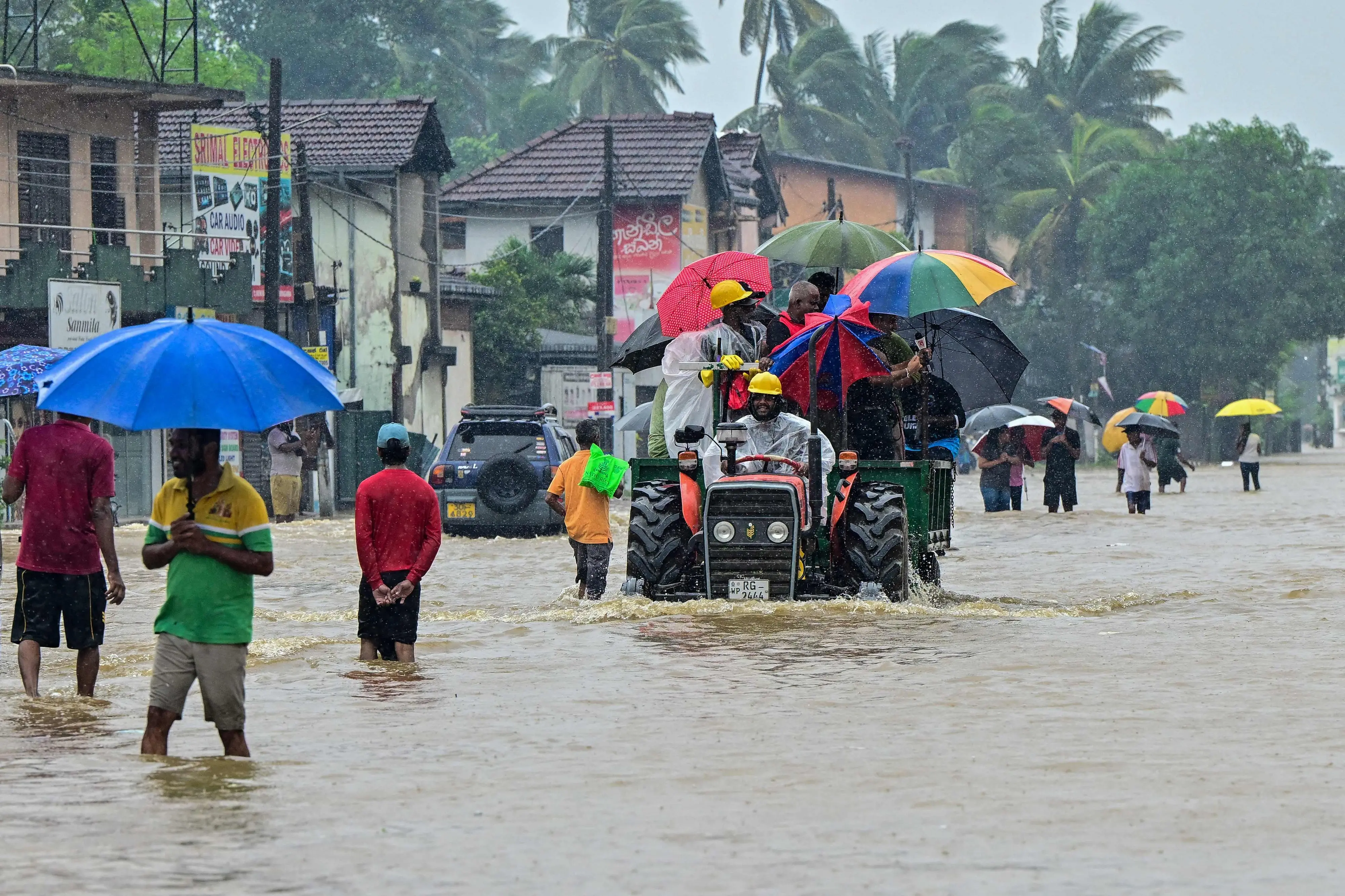 People move through a flooded road after heavy rainfall in Kaduwela on the outskirts of Colombo on November 28 | Photo: AFP