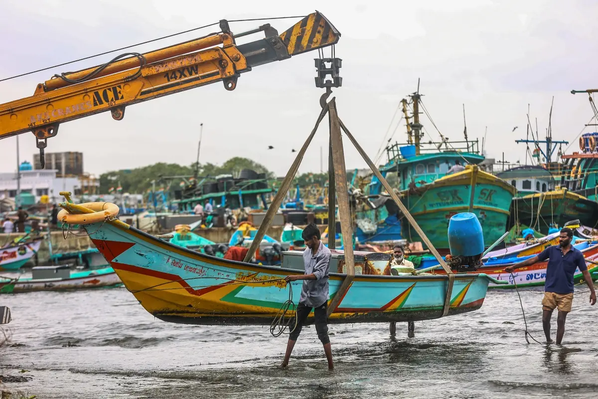 A fishing boat being carried to a safer place amid gusty winds in view of Cyclone 'Ditwah', at Kasimedu fishing harbour, in Chennai,