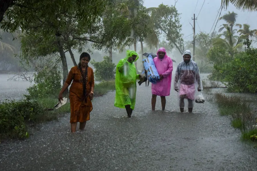 People wade through a flooded road