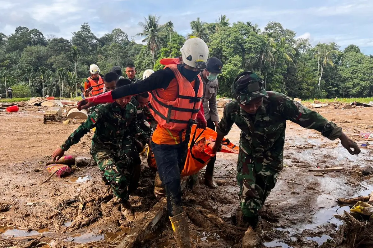 Rescuers carry the body of a flood victim in Indonesia | Photo: AP