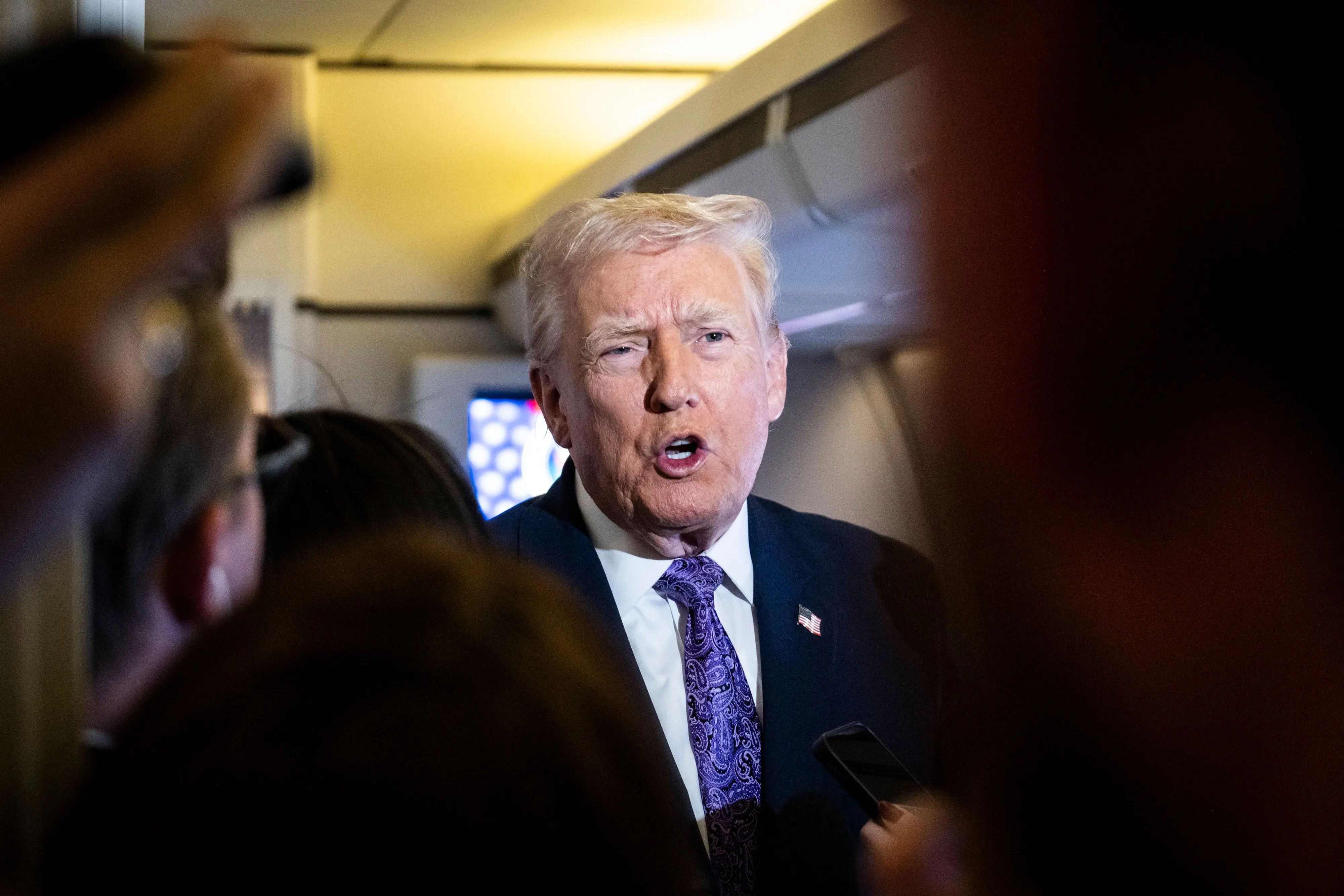 US President Donald Trump speaks to the press aboard Air Force One en-route to Washington | Photo: AFP