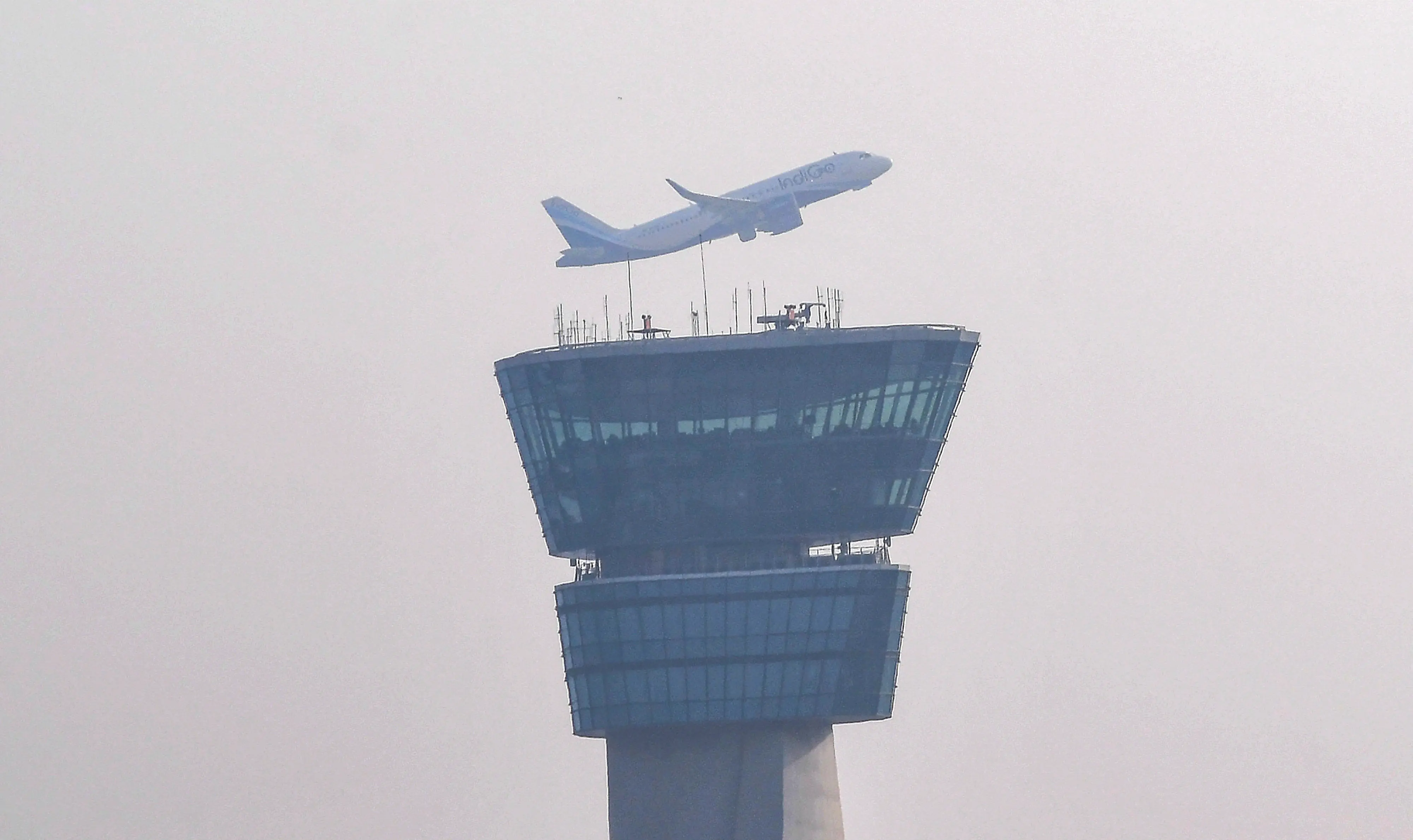 An aircraft takes off amid low visibility conditions as smog surrounds the air traffic control (ATC) tower at Chhatrapati Shivaji Maharaj International Airport in Mumbai | Photo: PTI