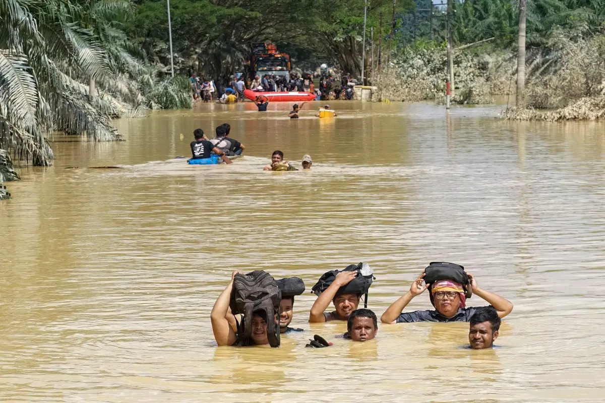 Residents wade through neck-deep floodwaters | Photo: AFP