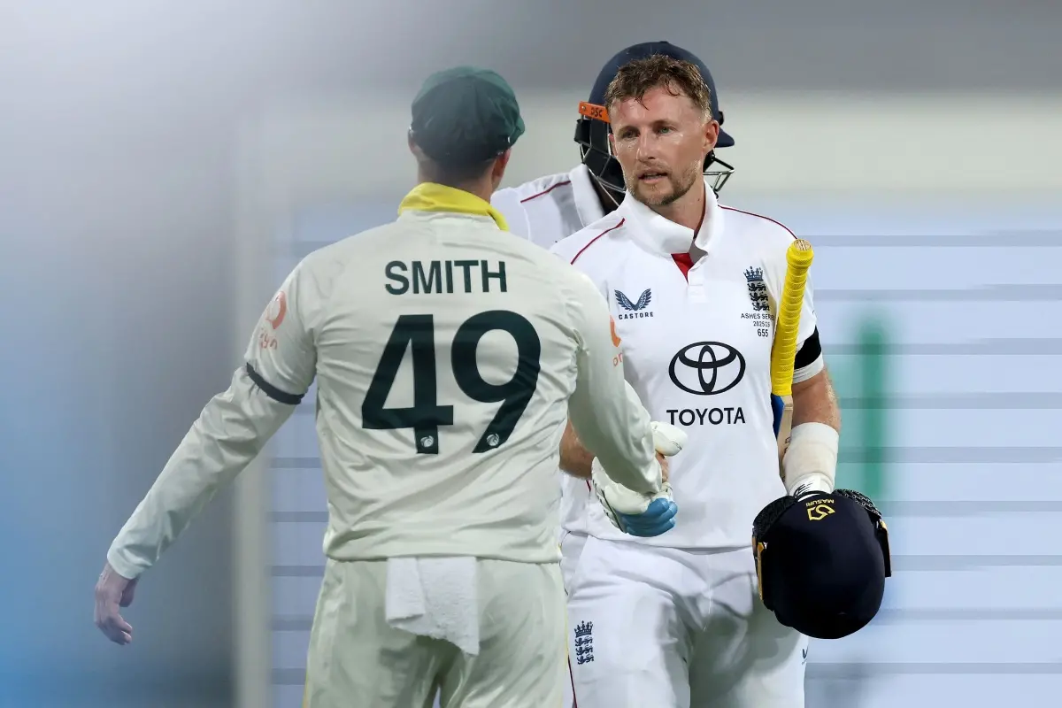 England's Joe Root (R) is congratulated by Australia's captain Steve Smith as he walks off the ground at the end of day one of the second Ashes cricket Test match between Australia and England at The Gabba in Brisbane. | Photo: AFP