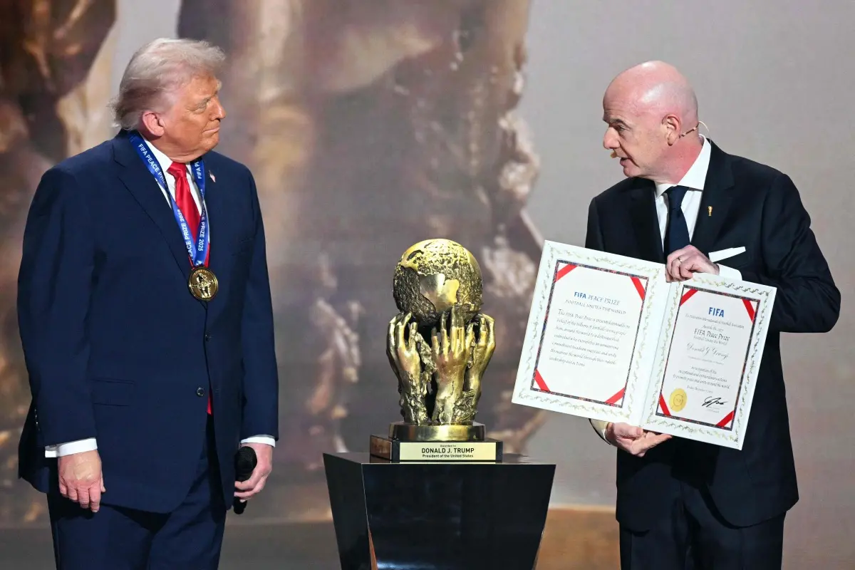 (L-R) US President Donald Trump receives the FIFA Peace Prize from Italian Fifa President Gianni Infantino during the draw for the 2026 FIFA Football World Cup taking place in the US, Canada and Mexico, at the Kennedy Center, in Washington, DC. | Photo: AFP