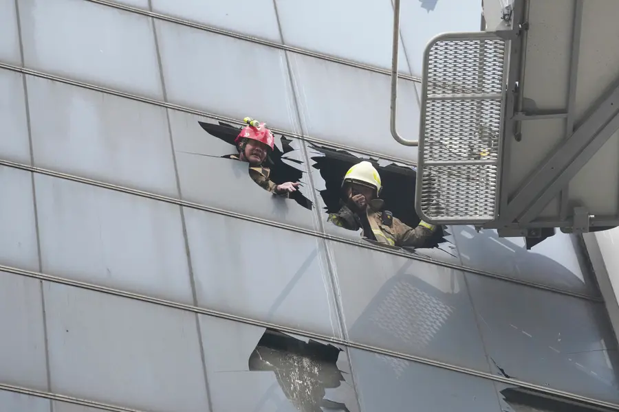 Firefighters work in an office building that caught fire in Jakarta
