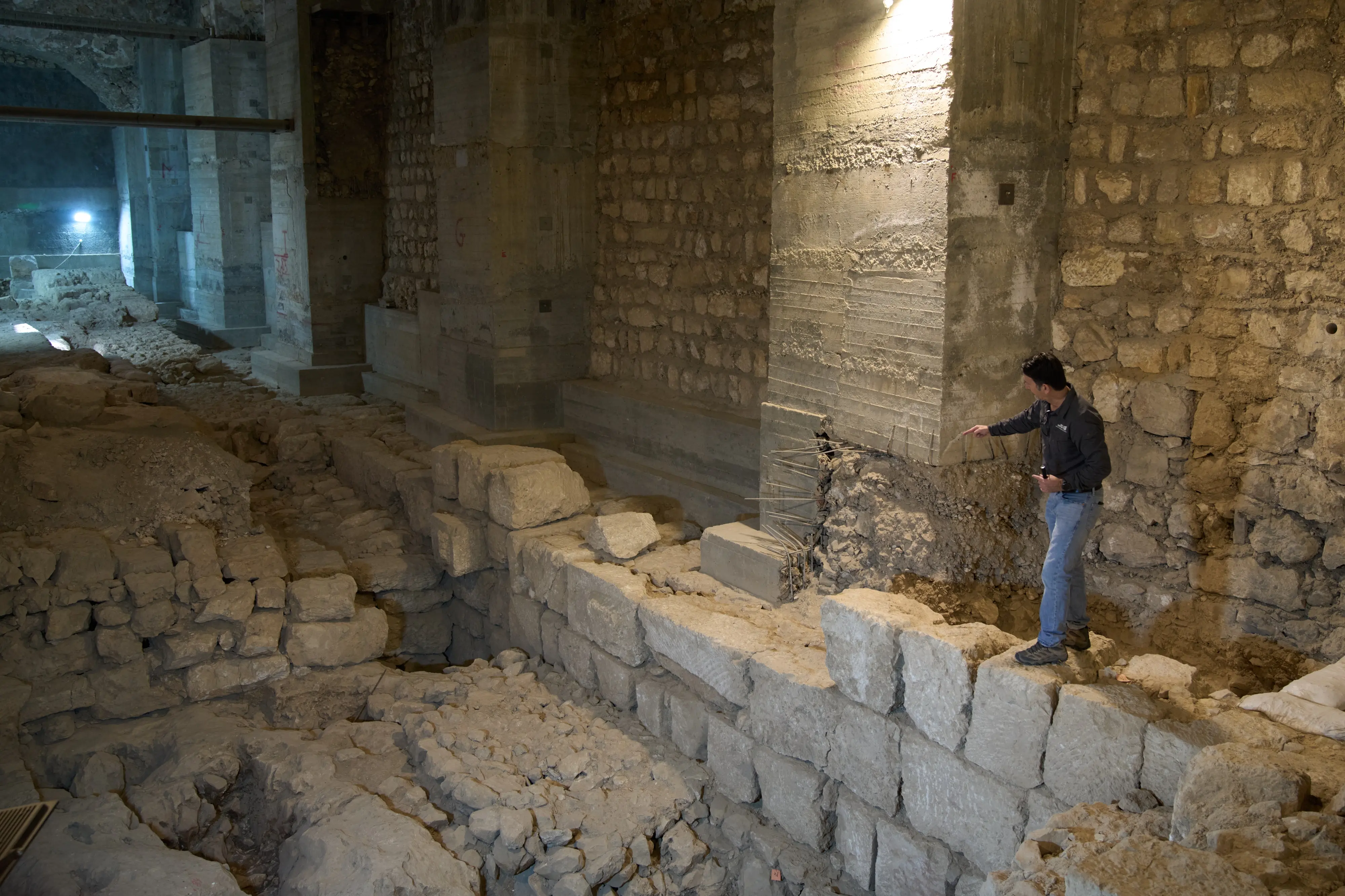 The Jerusalem Regional Archaeologist for the Israel Antiquities Authority, Dr. Amit Re'im, shows a section of an excavation site where, according to the institution, a city wall from the Hasmonean period, dating to the late 2nd century BCE, was uncovered under the Tower of David Citadel Museum, in the Old City of Jerusalem | AP