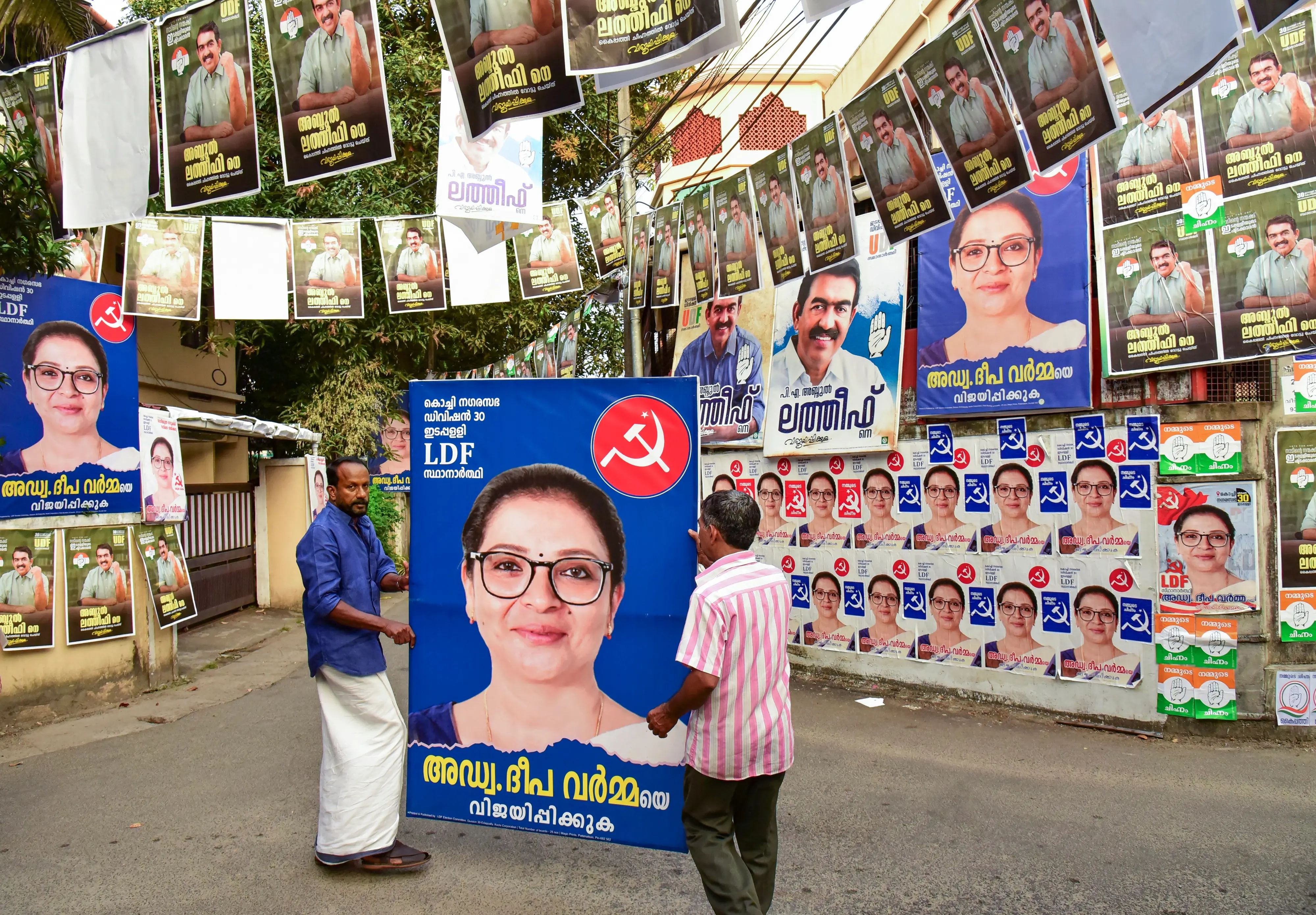 Political parties members put up posters ahead of the first phase of Kerala local body polls, in Ernakulam district | PTI