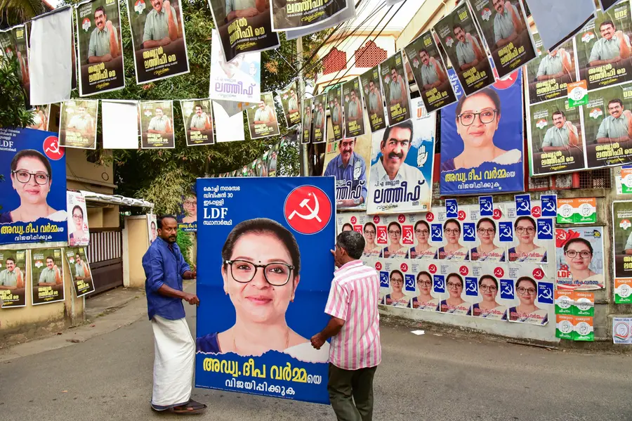 Political parties members put up posters ahead of the first phase of Kerala local body polls, in Ernakulam district