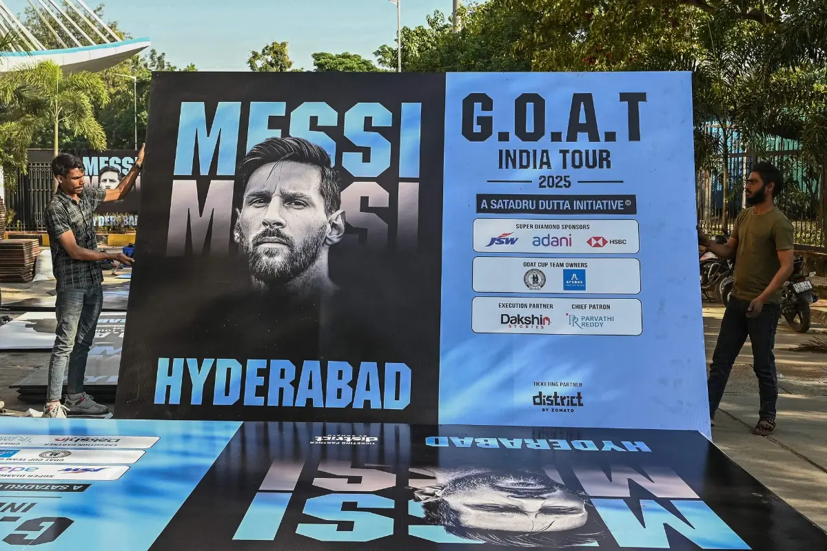 Workers carry a poster of Argentina's footballer Lionel Messi in Hyderabad | Photo: AFP