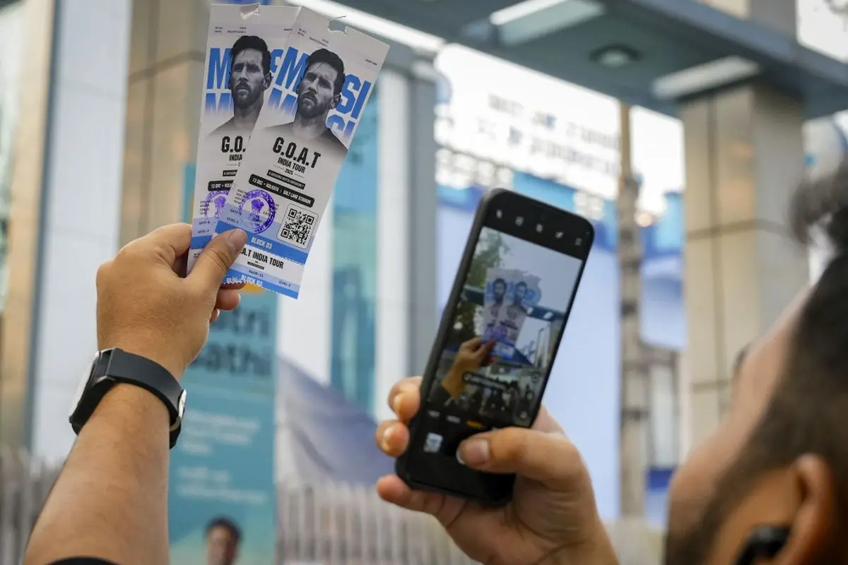 A fan clicks photos of tickets for Lionel Messi's 'GOAT Tour India 2025' at the Vivekananda Yuba Bharati Krirangan stadium, in Kolkata.