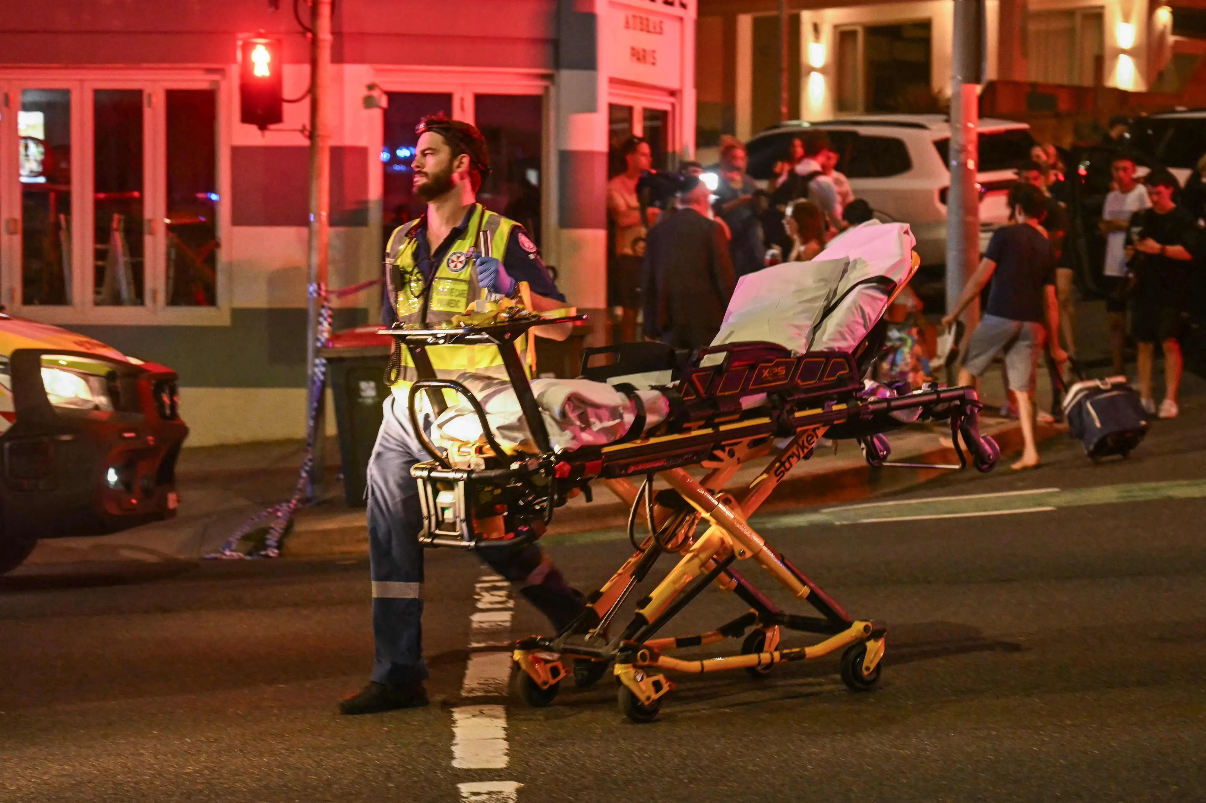 A health worker moves a stretcher after a shooting incident at Bondi Beach in Sydney | AFP