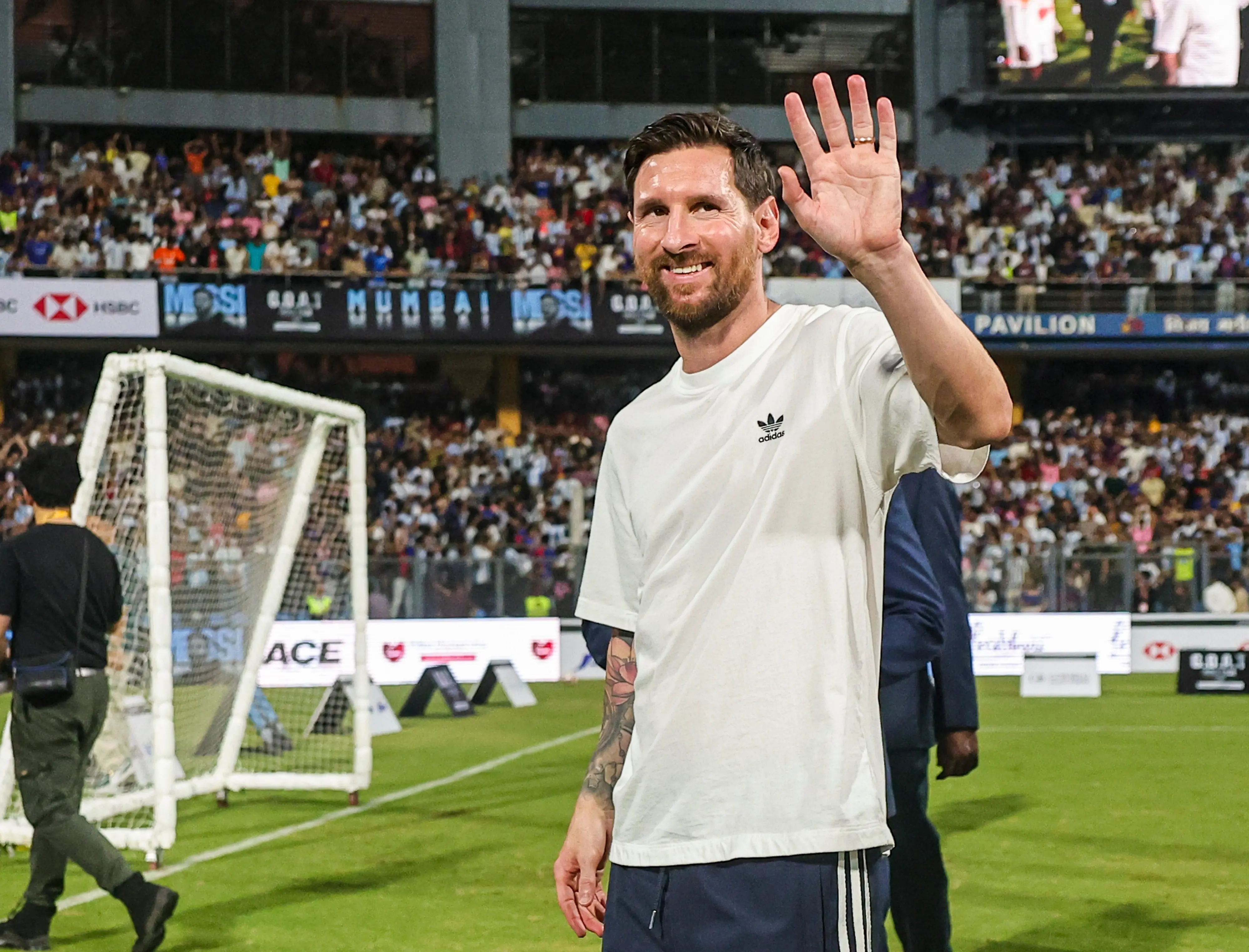 Argentine footballer Lionel Messi greets the gathering during the 'GOAT India Tour 2025' at Wankhede Stadium in Mumbai | Photo: PTI