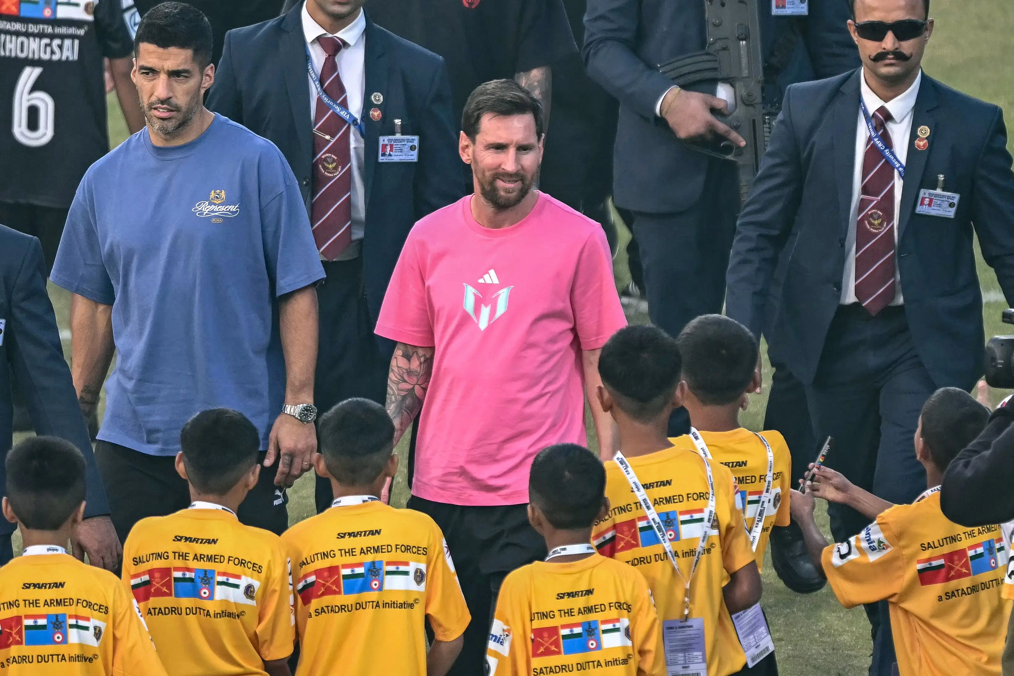 Argentina's footballer Lionel Messi (C), along with Uruguayan footballer Luis Su&aacute;rez (L), arrives to attend an event during his GOAT Tour at the Arun Jaitley Stadium in New Delhi | AFP