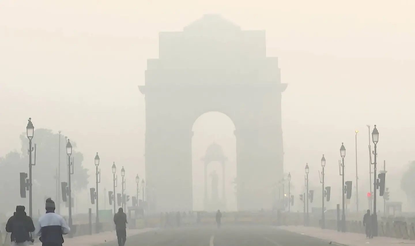 Vehicles commute through the India Gate area covered with smog | Photo: ANI