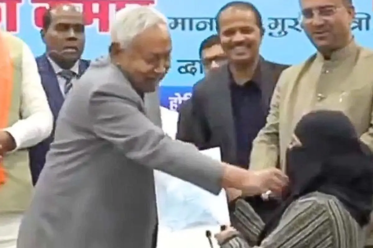 Bihar Chief Minister Nitish Kumar is seen interacting with a woman during an official event where appointment letters were distributed to newly appointed AYUSH doctors, moments from a video that later went viral and triggered a political controversy over allegations of inappropriate conduct. Photo: X