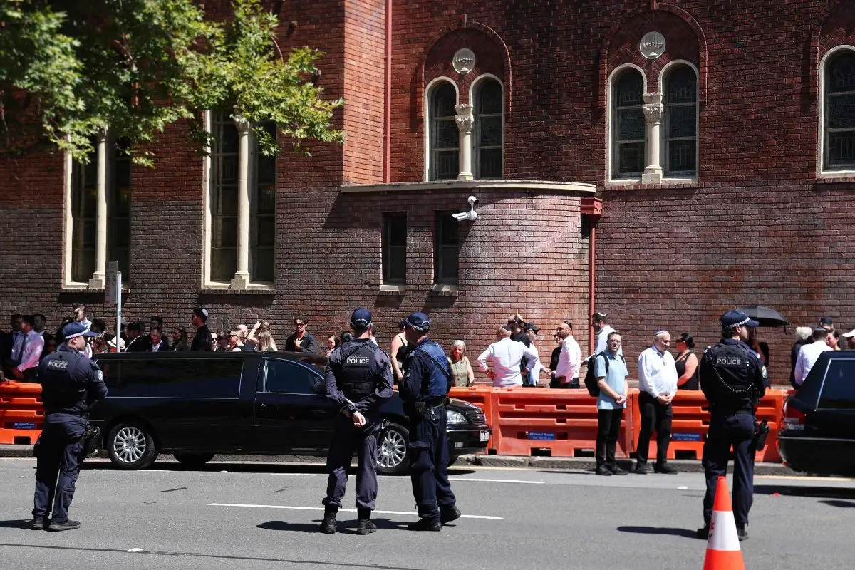 Police stand guard after the funeral of Boris and Sofia Gurman, who were killed in the December 14 Bondi Beach shooting attack, in Sydney on December 19, 2025. (Photo by DAVID GRAY / AFP)