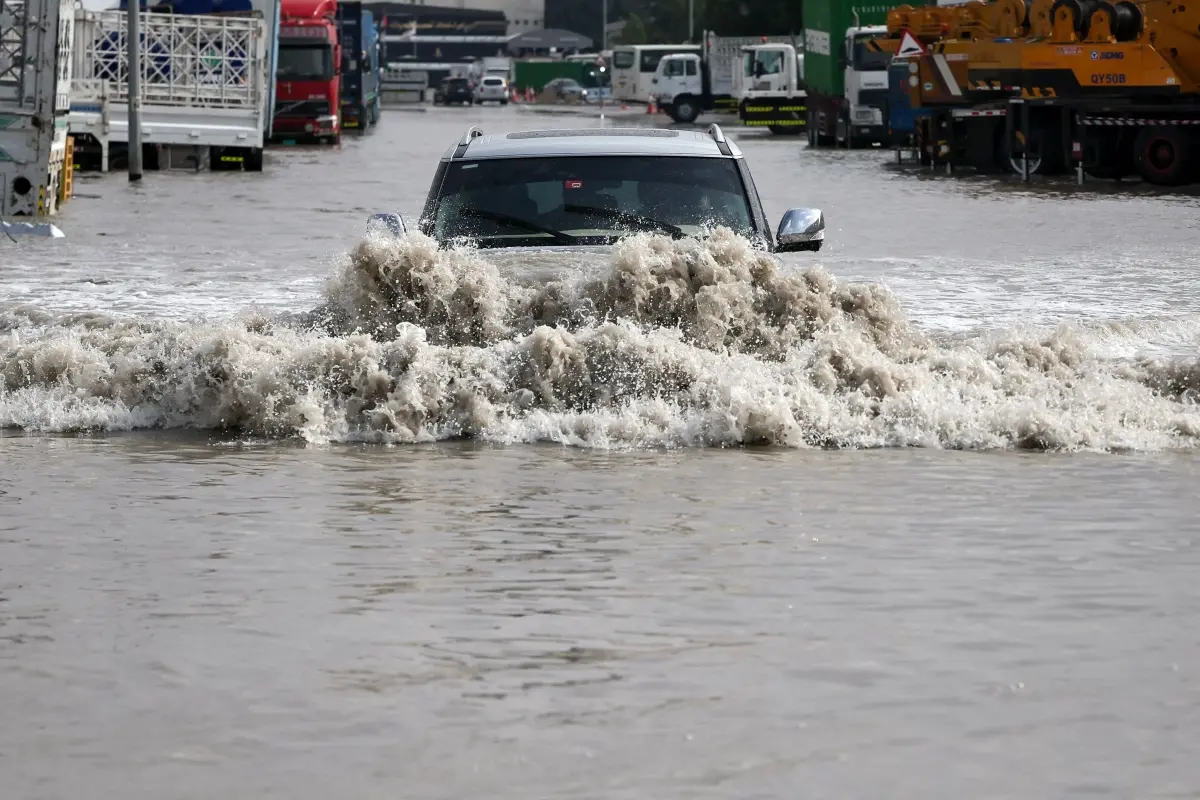 A vehicle drives through flood waters following heavy rains, in Dubai