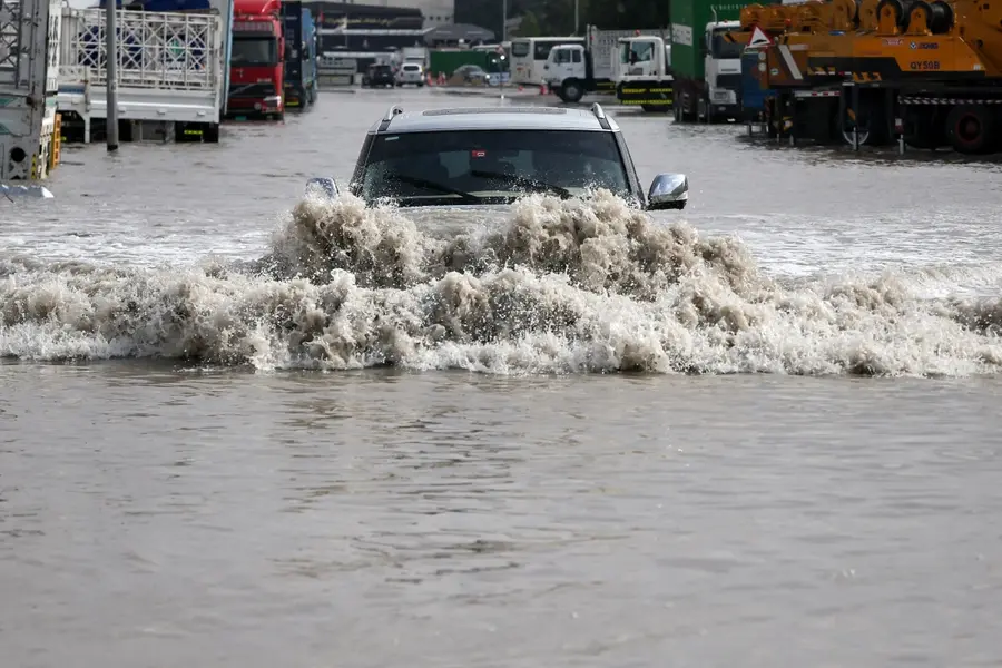 A vehicle drives through flood waters following heavy rains, in Dubai