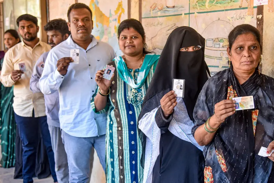 Voters wait in queues to cast their votes during the Municipal Council elections at a polling station , in Karad, Maharashtra