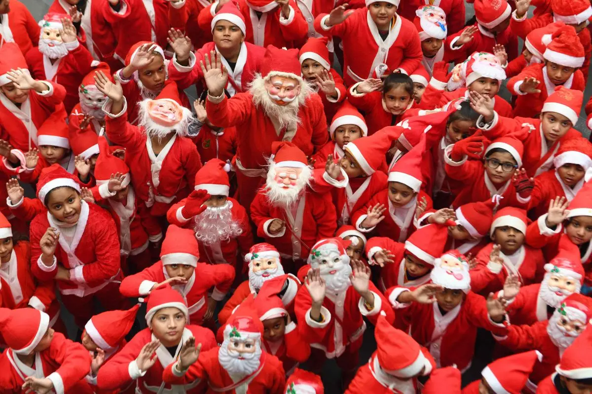 Children dressed as Santa Claus gestures during Christmas celebration | Photo: AFP