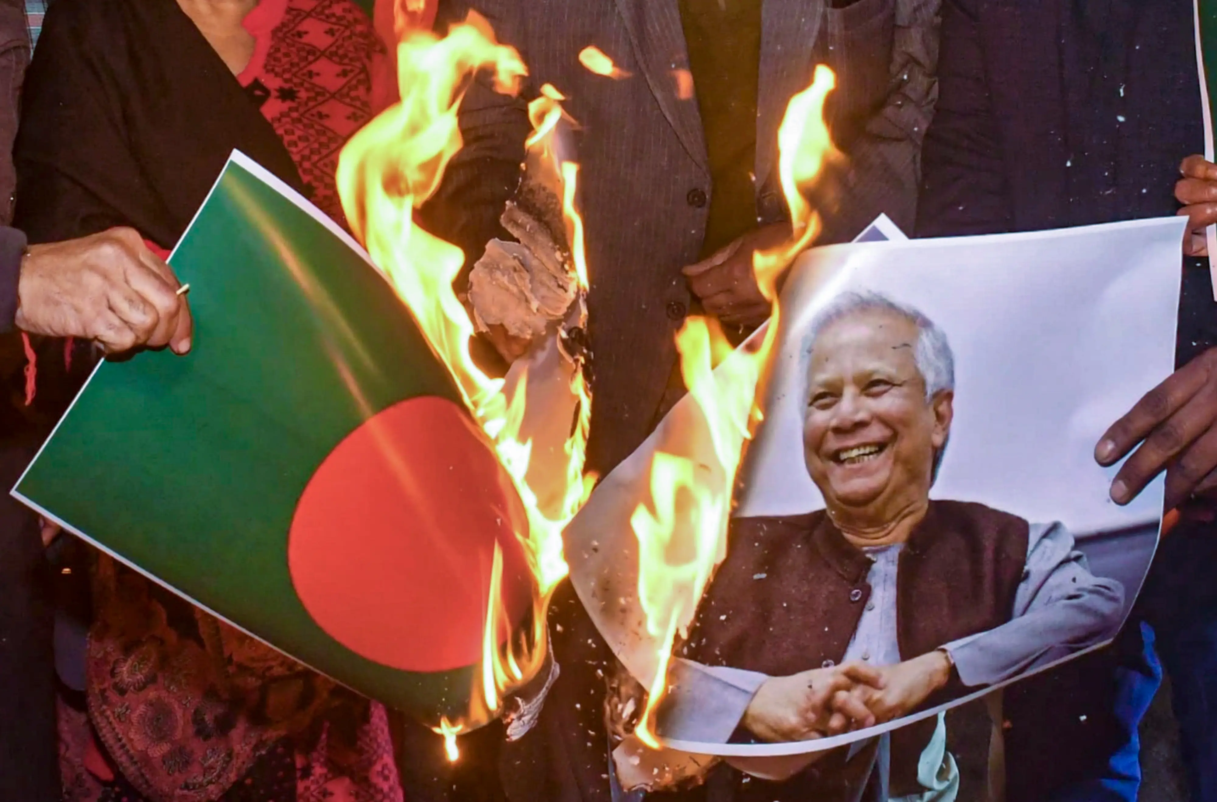 Congress workers burn photos of Bangladesh's flag and Chief Adviser Muhammad Yunus during a protest over alleged atrocities and human rights violations against minority Hindus in Bangladesh | PTI