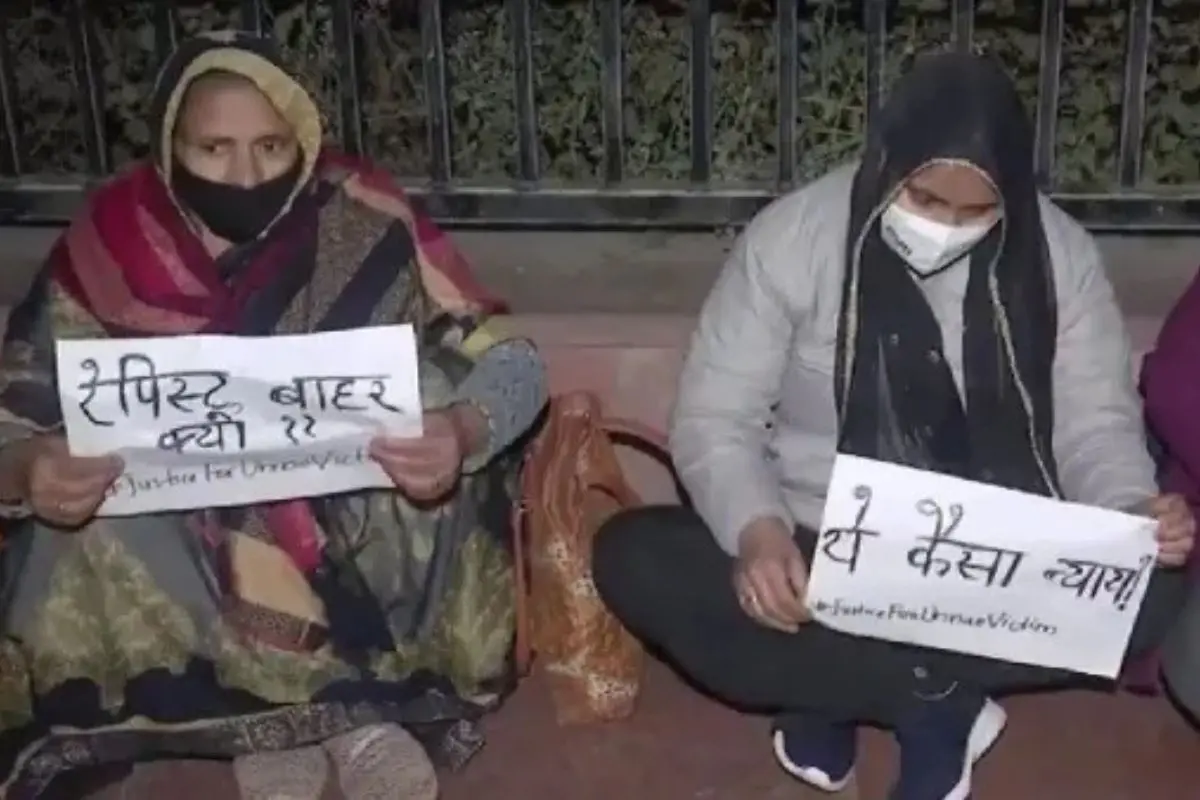 The Unnao rape survivor's mother (Left) holds placards demanding justice. Photo: IANS