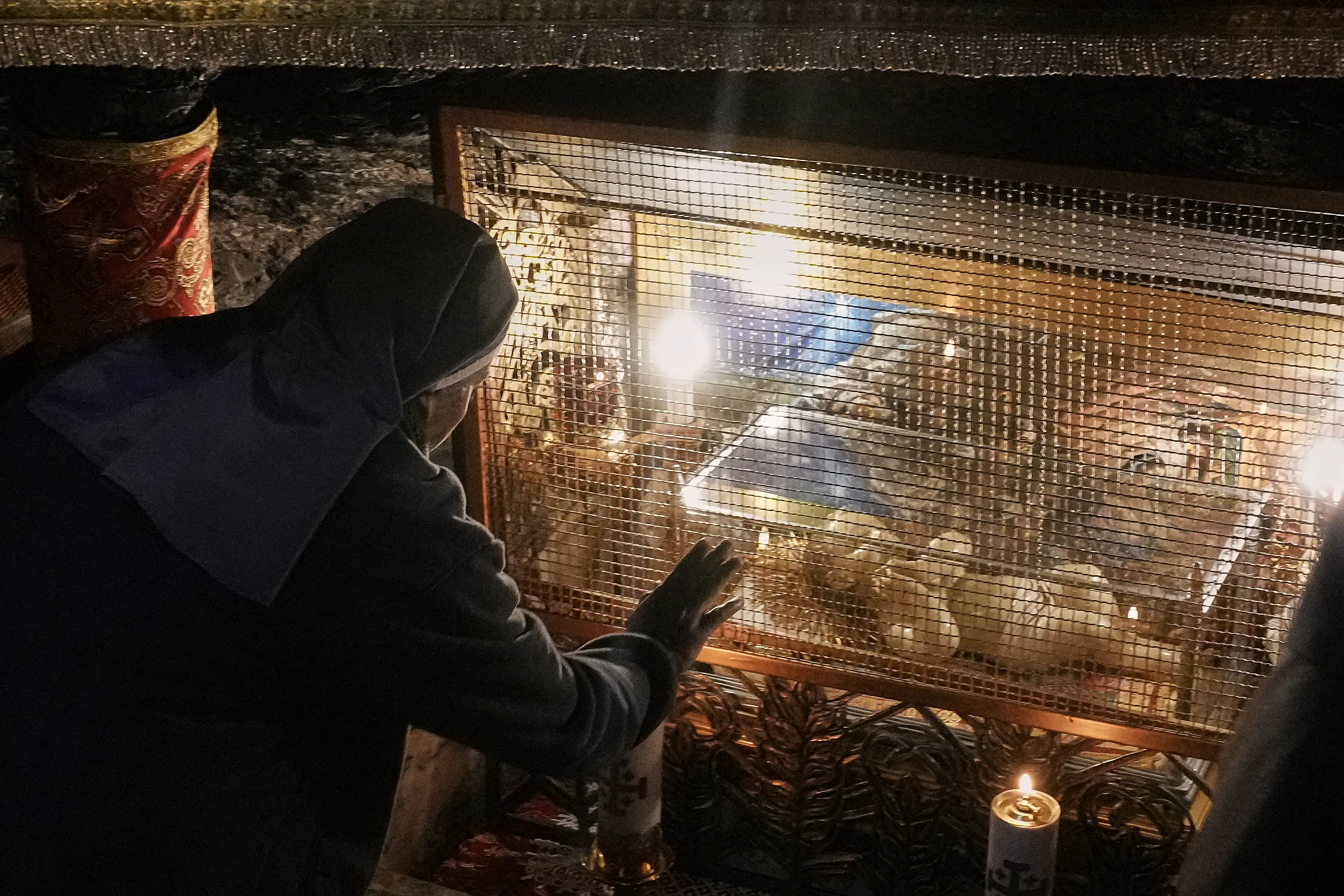 A Catholic nun prays next to a statue of Baby Jesus in the Grotto under the Church of the Nativity, traditionally believed to be the birthplace of Jesus, on Christmas Day, in the West Bank city of Bethlehem.| Photo: AFP