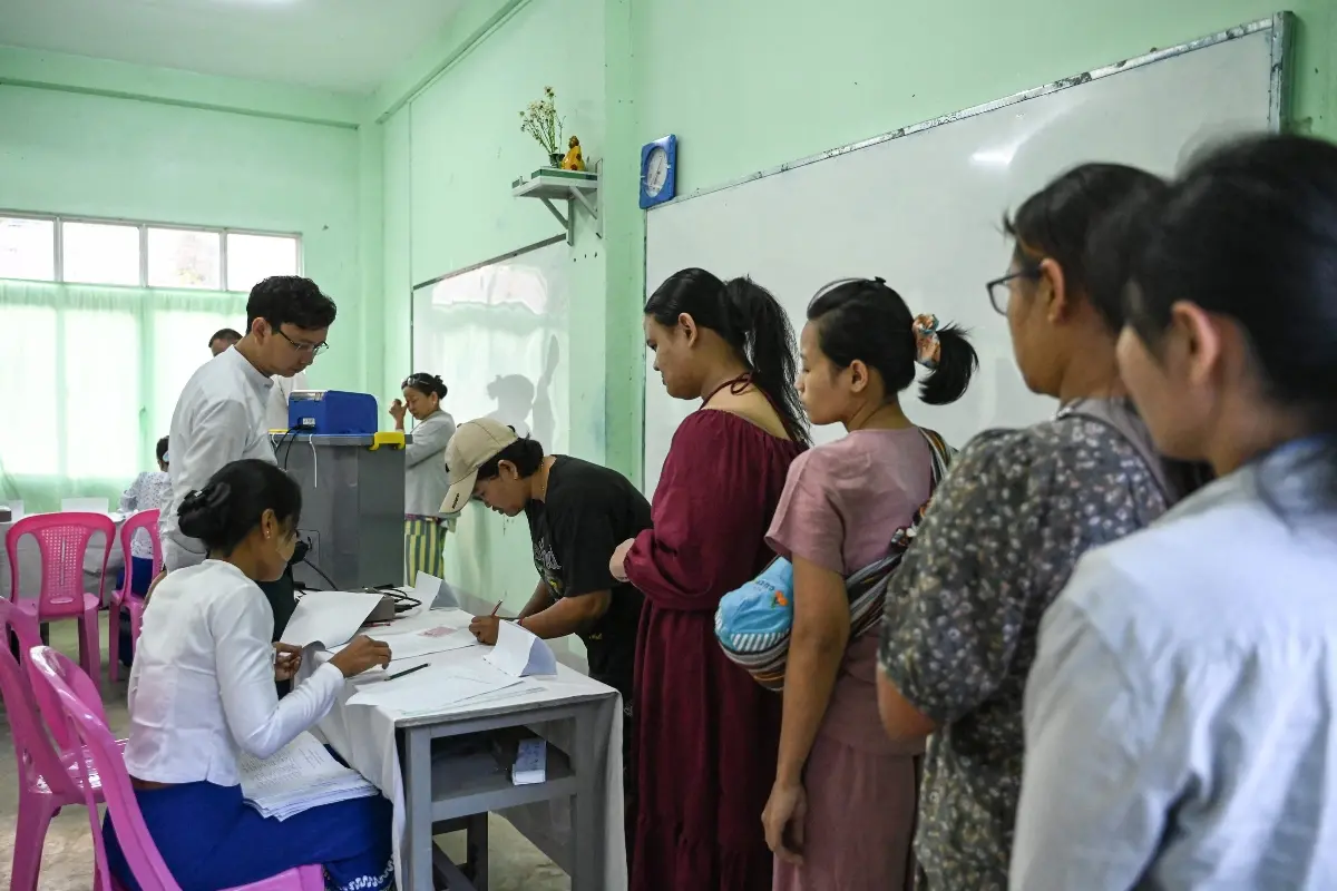 People line up to vote inside a polling station during the first phase of Myanmar's general election in Yangon | Photo: AFP