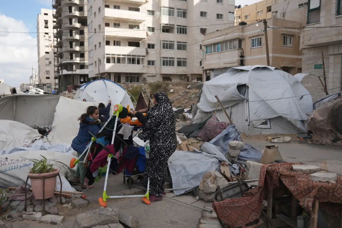 Members of the Al-Ajouri family stand by their tent that was destroyed by a strong wind and rain in Gaza City, Sunday, Dec. 28, 2025 (Photo: AP)