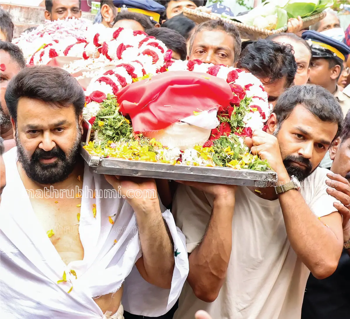Mohanlal and his son Pranav Mohanlal carry the body of his mother Santhakumari Amma to the pyre arranged in the yard of their residence at Mudavanmukal in Thiruvananthapuram | Photo: B Muraleekrishnan/Mathrubhumi