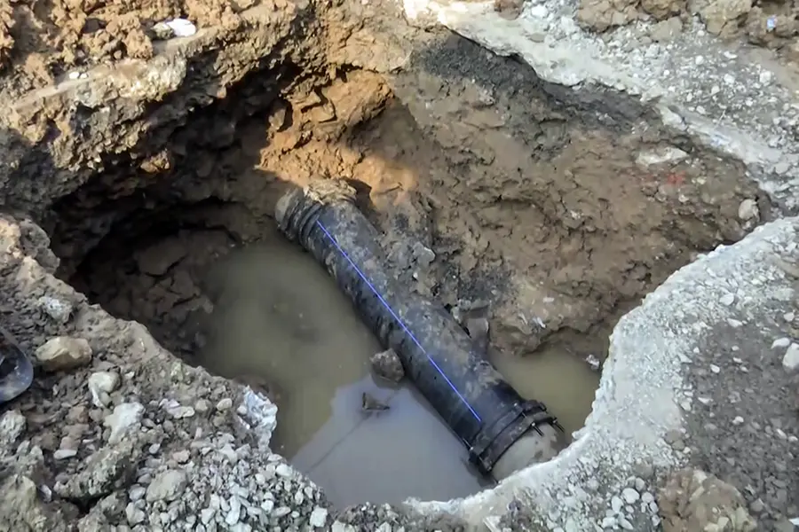 A water pipeline being dug out after eight people died due to contaminated water