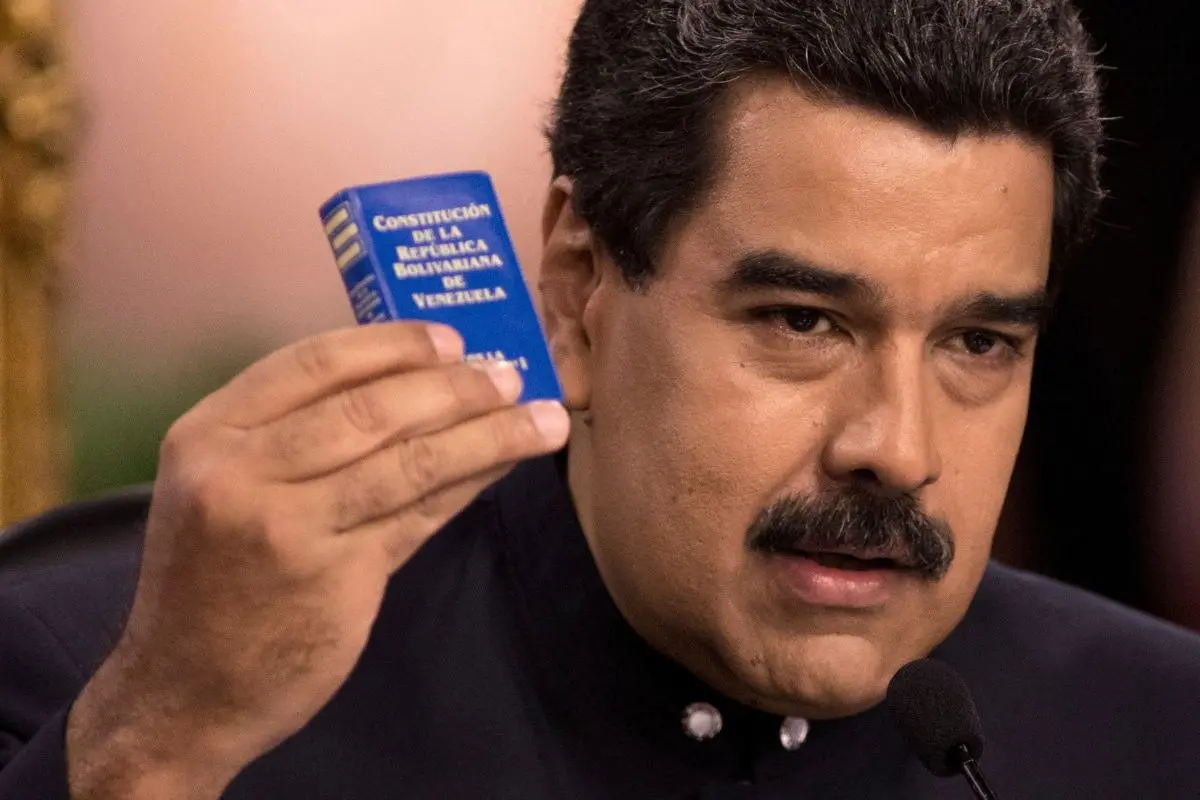 Nicolas Maduro holding a copy of the constitution, during a news conference in Caracas, Venezuela in 2017.