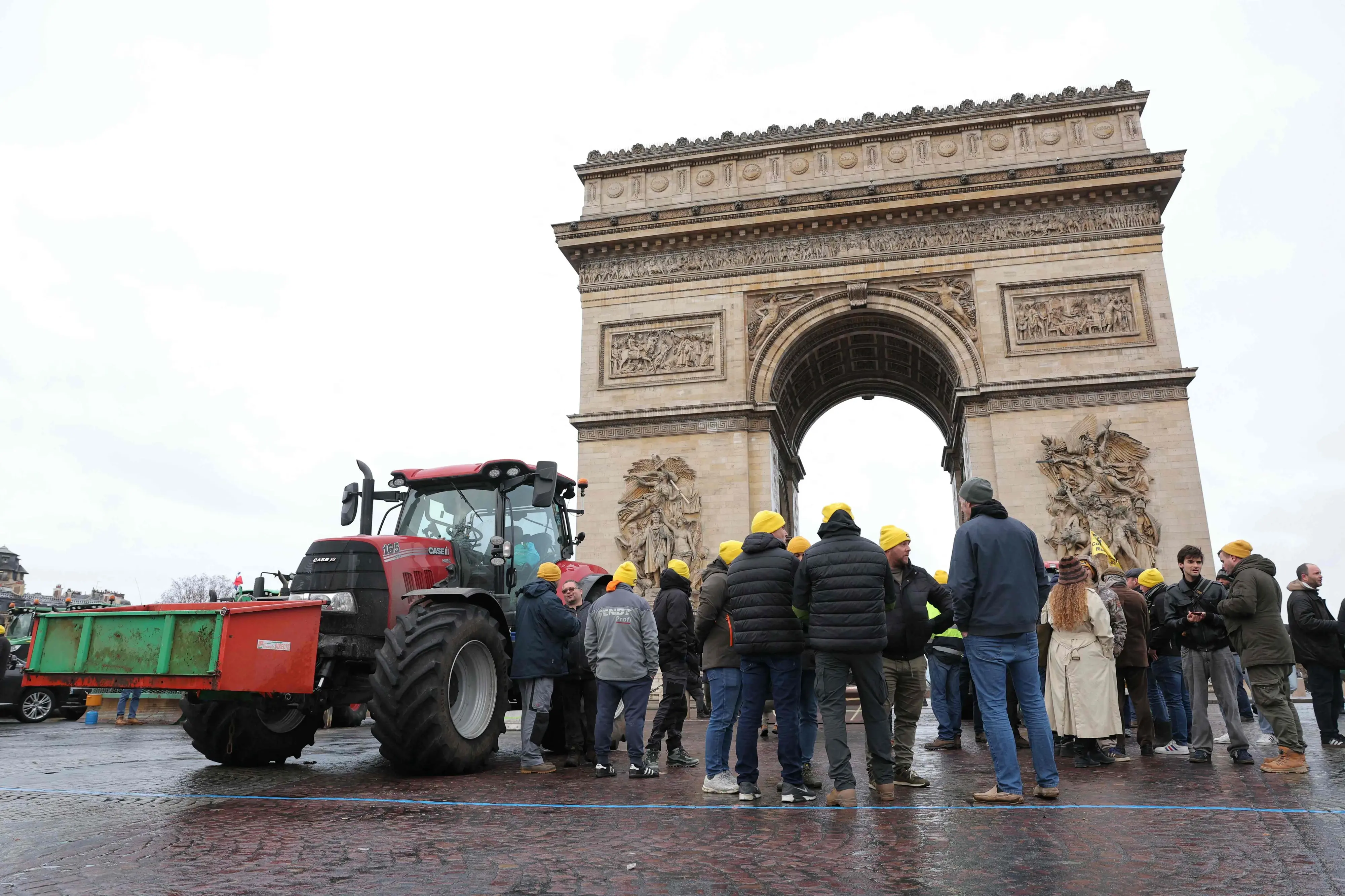 Farmers gather next to a tractor parked in front of the Arc de Triomphe during a demonstration of French agricultural union Coordination Rurale (CR) as part of a nationwide day of protests and actions called by several farmers unions to push the French government to block the Mercosur trade deal and protest against its handling of the nodular dermatitis (CND) epidemic, in Paris on January 8, 2026.| Photo: AFP